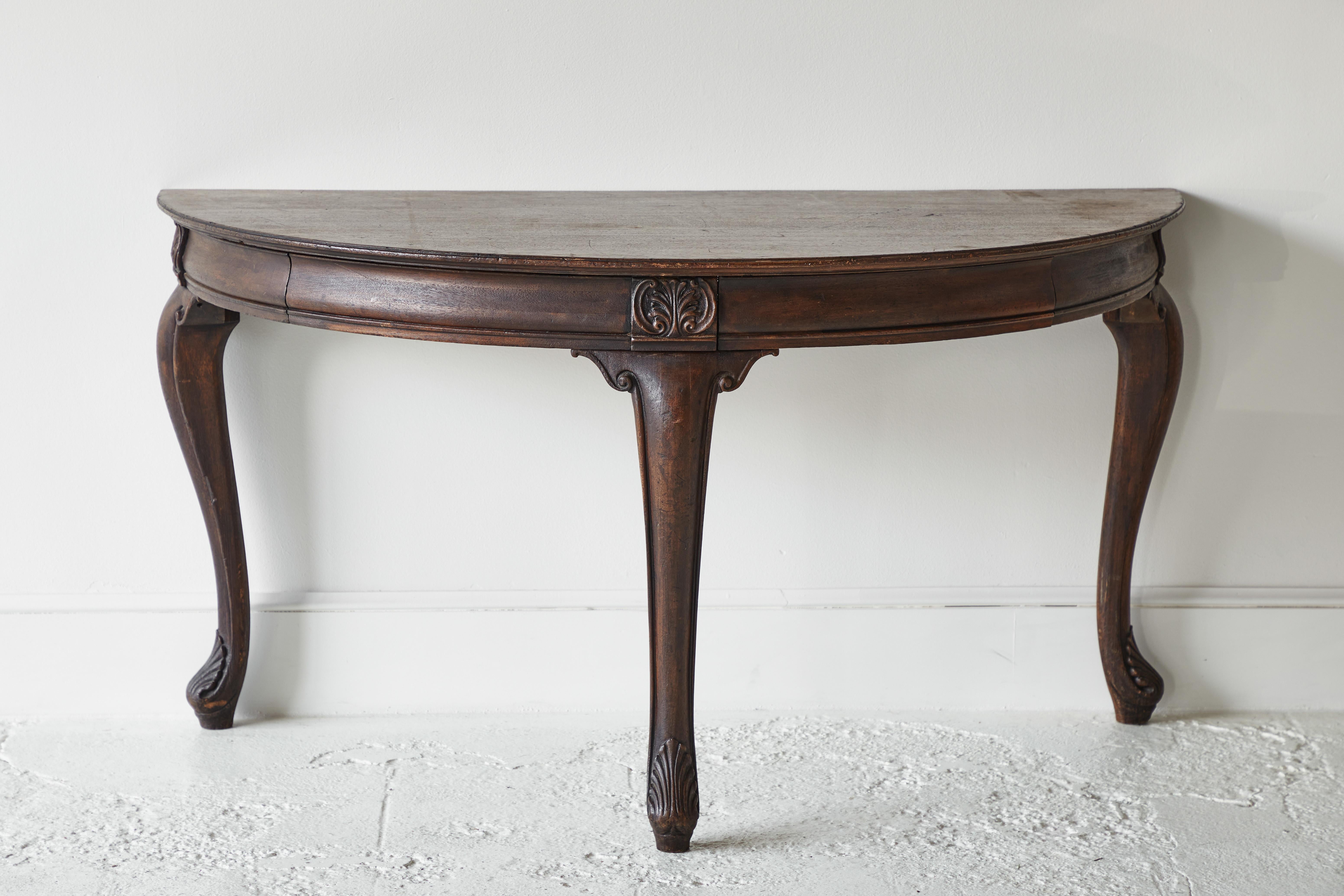 Early American demilune table with cabriole legs and ornate detail along the apron.