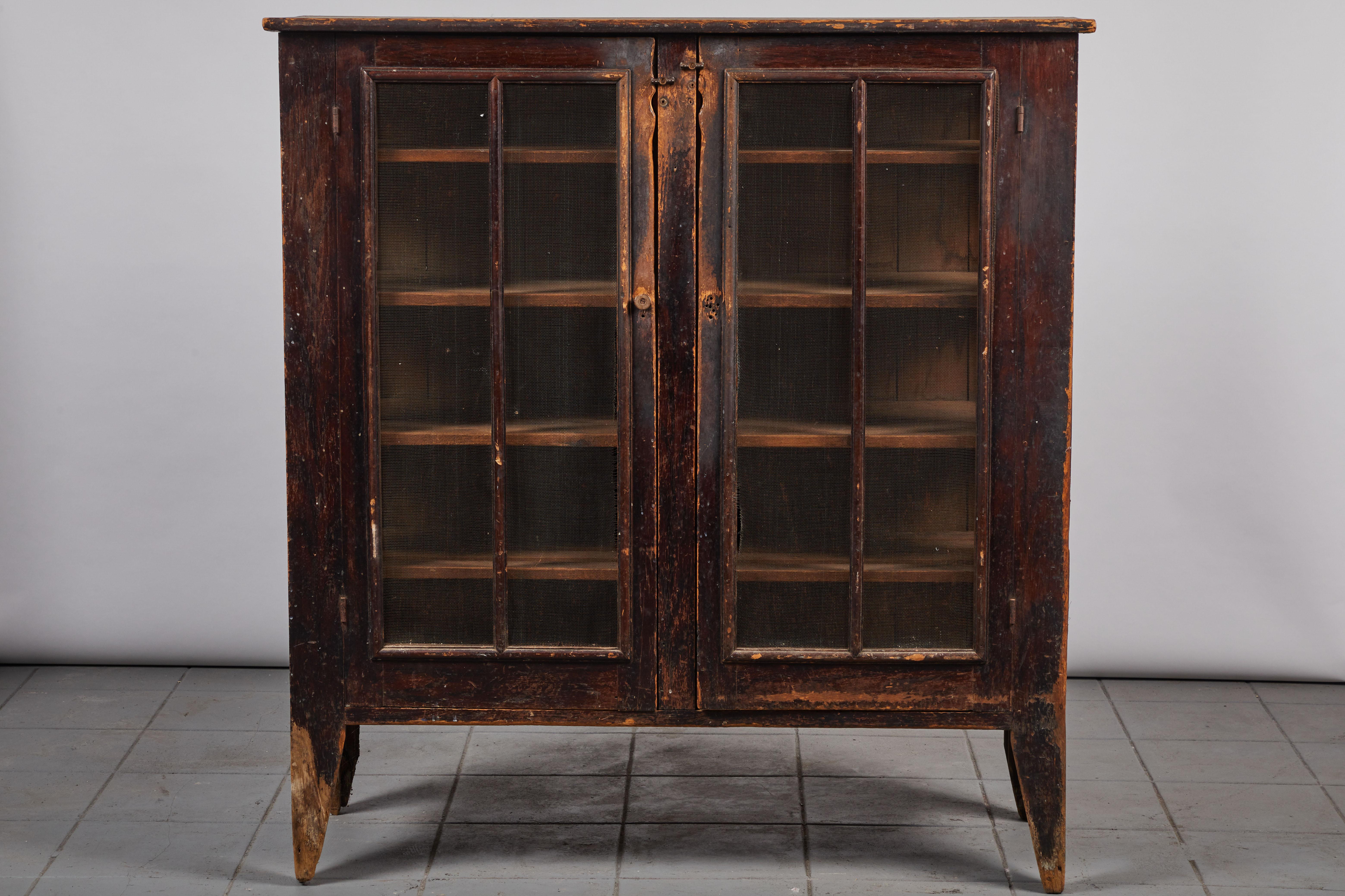 Early American dark stained two door screened pie safe with four interior shelves.