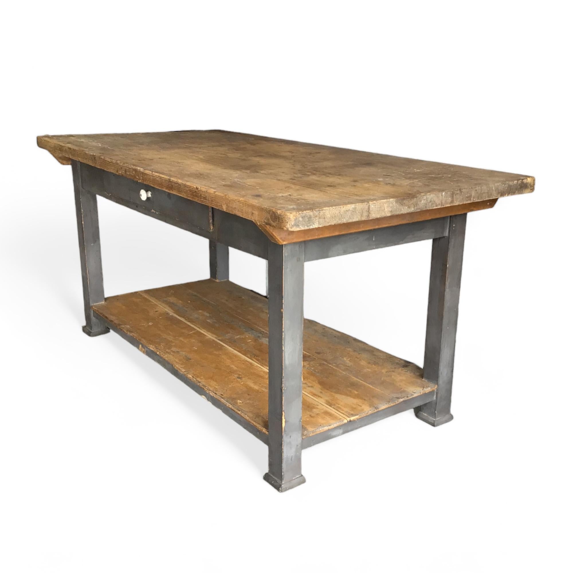 Cette table de ferme vintage en bois massif dispose d'un tiroir et d'une étagère inférieure pour un rangement supplémentaire avec un plateau amovible. Parfait comme table de travail ou console. 