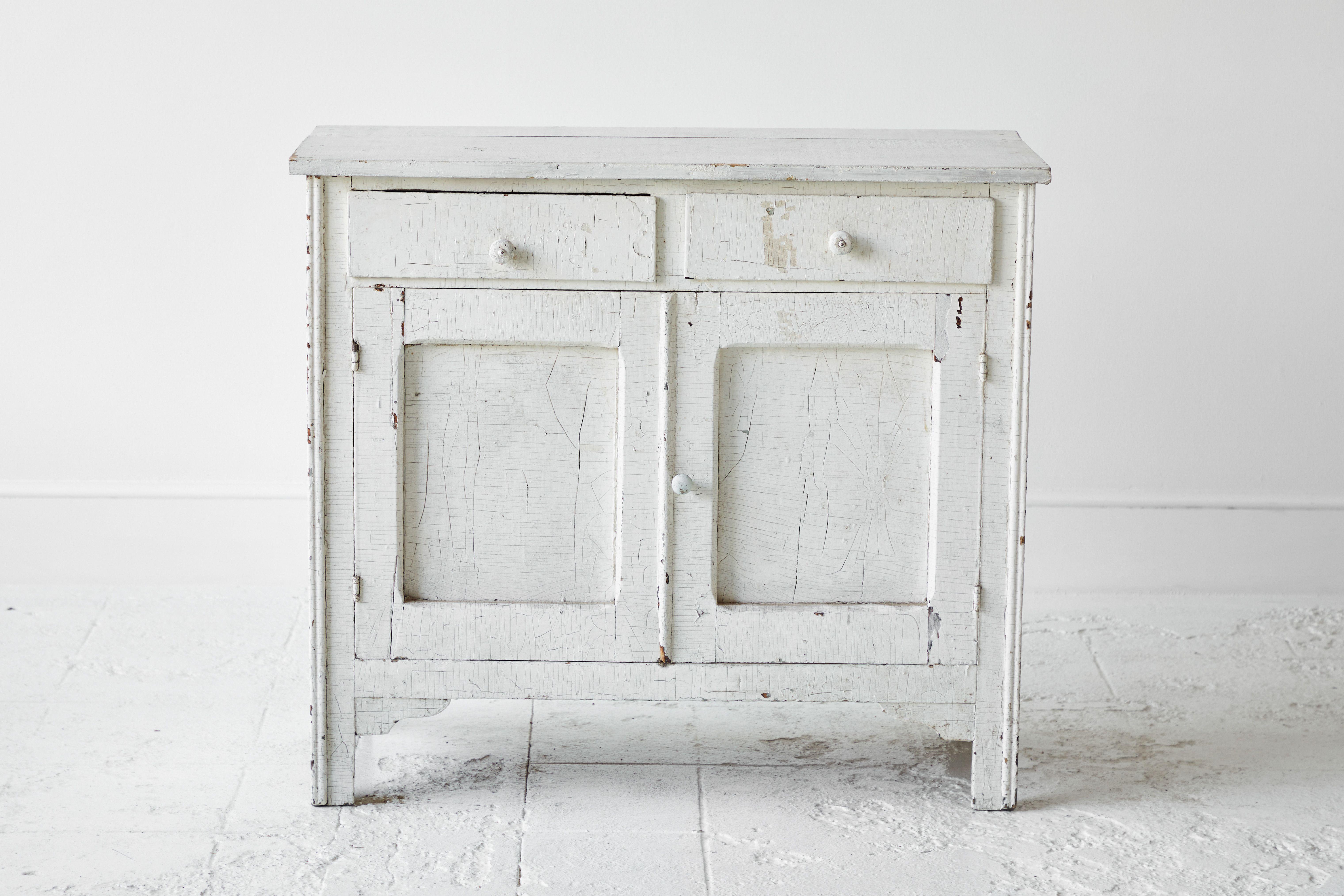 Rustic Early American white painted server with two drawers and two doors. The paint is original and boasts patina and charm.