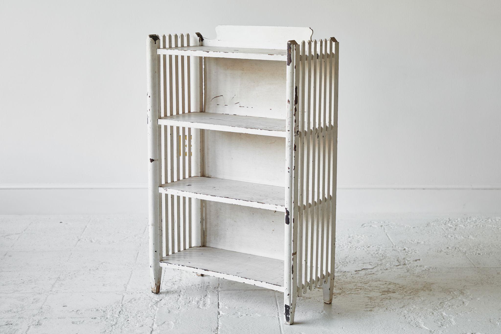 Early American white painted shelf with four shelves and slatted sides.