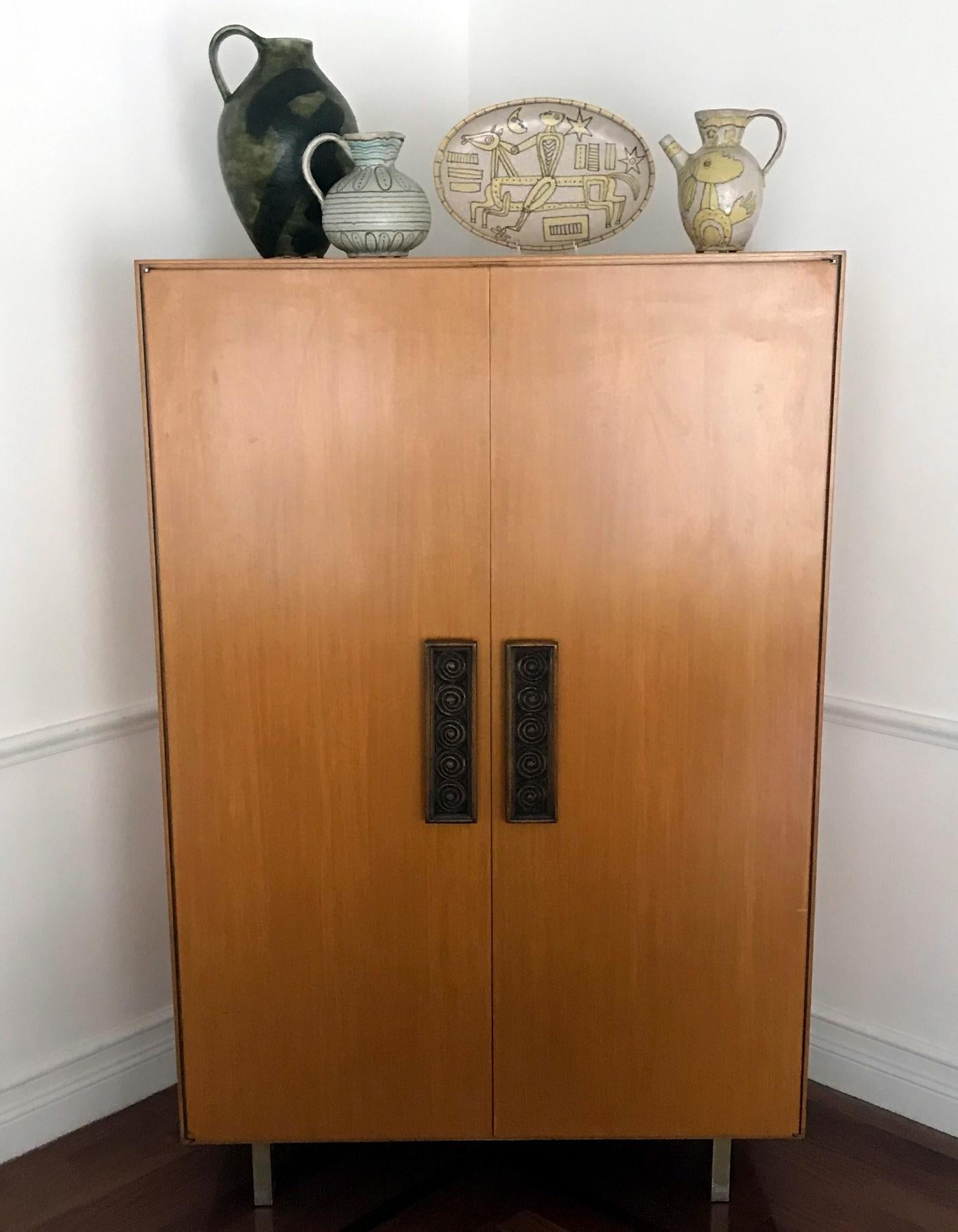 Dated from 1950s, designed by Vladimir Kagan and manufactured by Kagan-Dreyfuss Inc, New York, this rarely seen model of armoire features an elegant bleached mahogany exterior with metal legs and an fitted interior with shelves and drawers. The