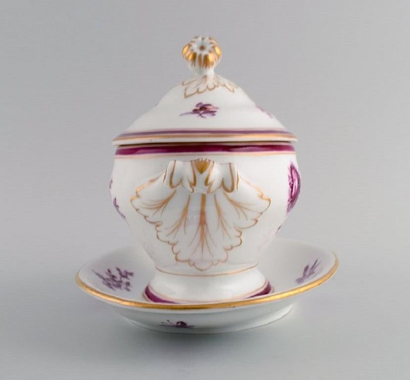 Early and rare Bing & Grøndahl lidded tureen in hand-painted porcelain with purple flowers and gold decoration. 
Lid bud modelled as a rosebud. 
Early 20th century.
Measures: 25 x 17 x 17 cm.
In excellent condition.
Signed.