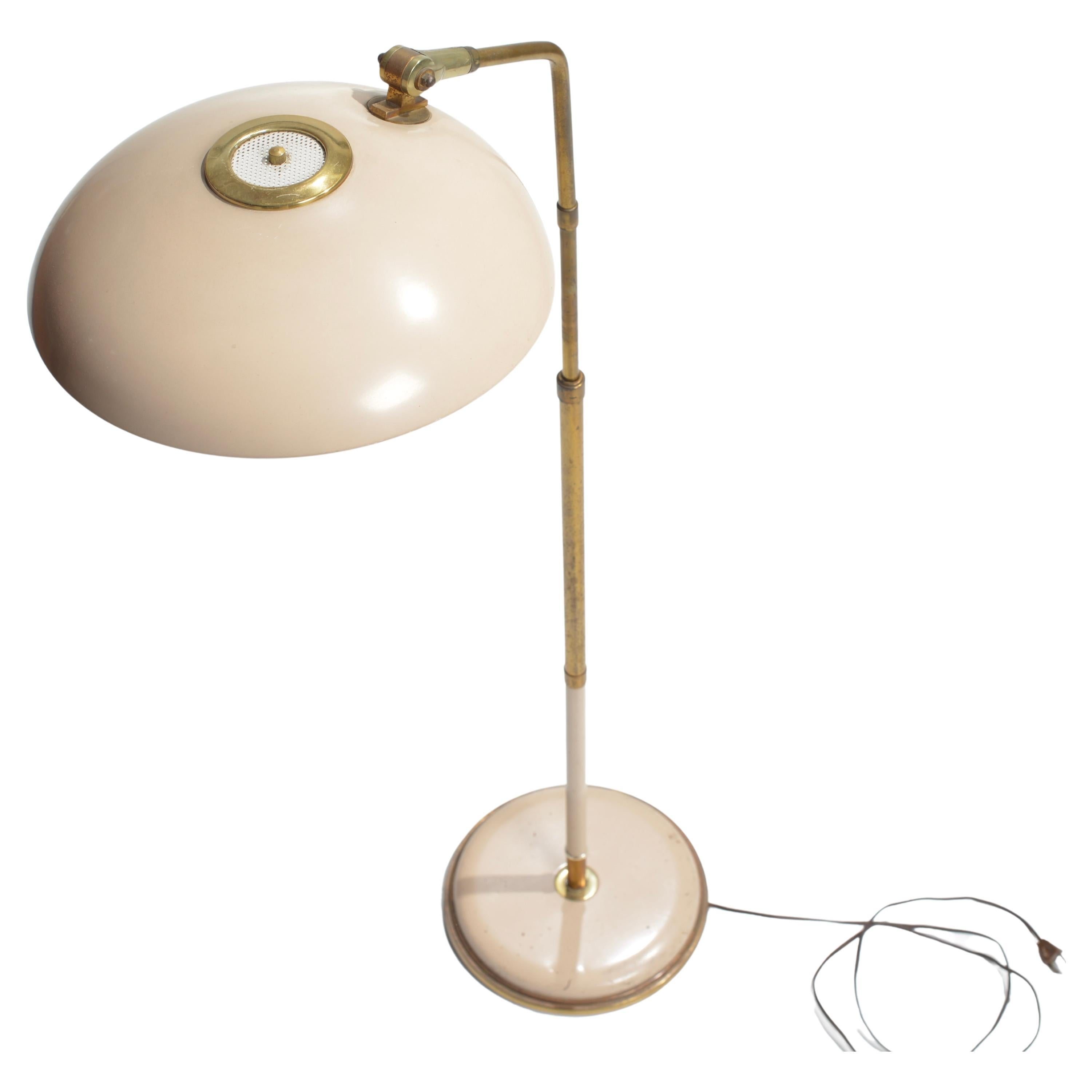 Rare adjustable floor, reading, lamp designed by Gerald Thurston for Lightolier. Iconic saucer shade lams in creme/tan color, with brass elements. The saucer shade tilts, while the total height is adjustable. Very rare!