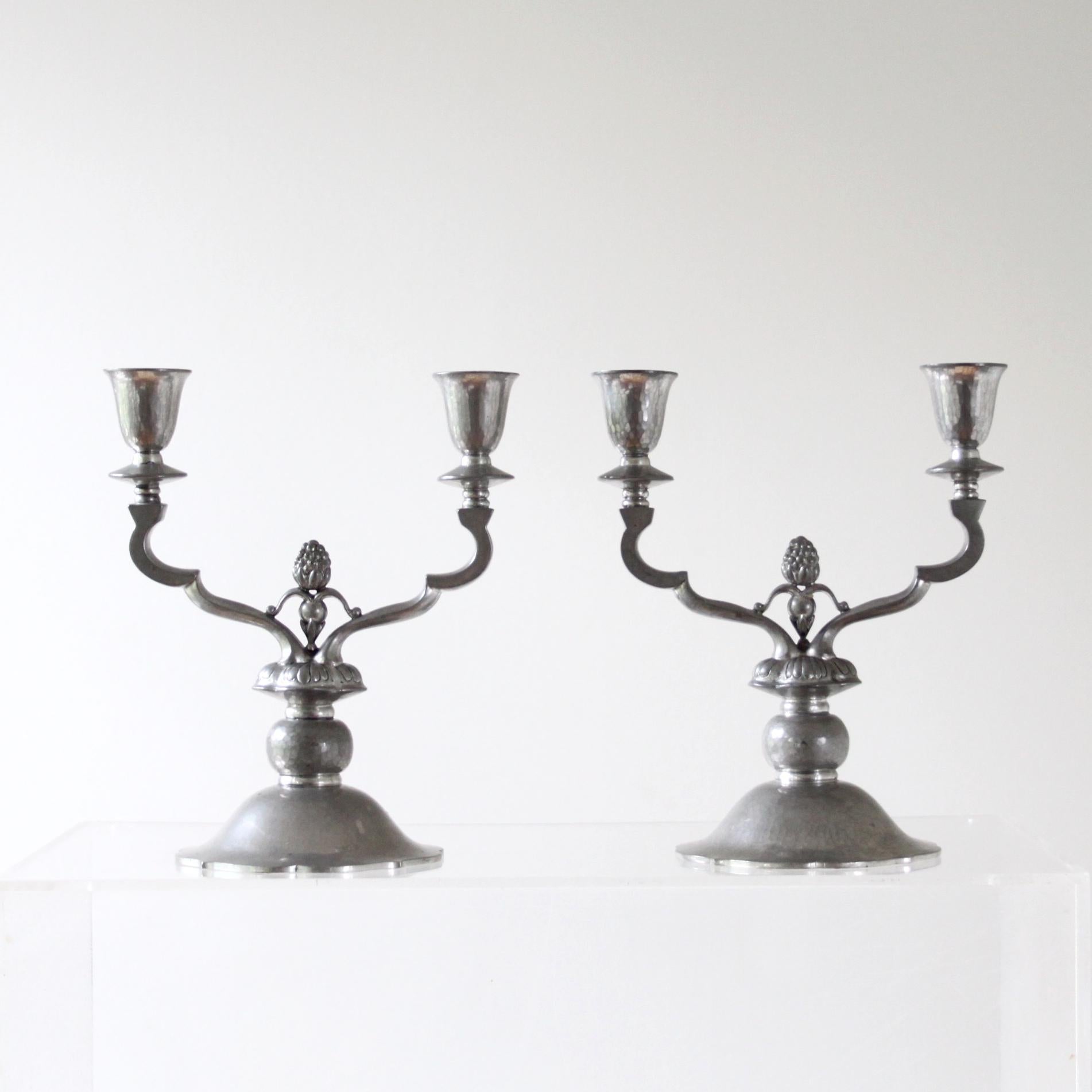 Just Andersen - Scandinavian modern.

A early and rare pair of pewter candelabras with three arms, Dessin 307, manufactured in Denmark, 1930. The candelabras have very fine decoration with hammered and hand-crafted details. 

Each candelabra stamped