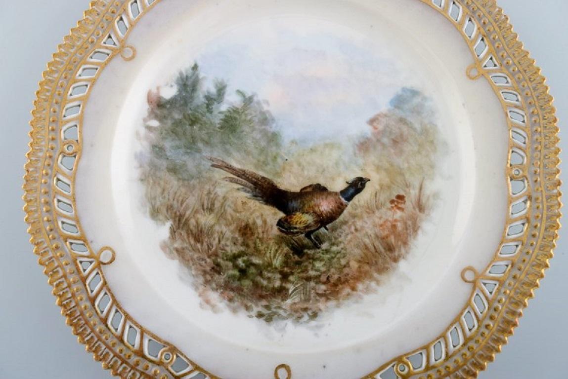 Early and rare Royal Copenhagen fauna danica plate in hand-painted porcelain with hunting motif and gold decoration. 
19th century.
Diameter: 23 cm.
In excellent condition.
Stamped.
3rd factory quality due to the porcelain mass.