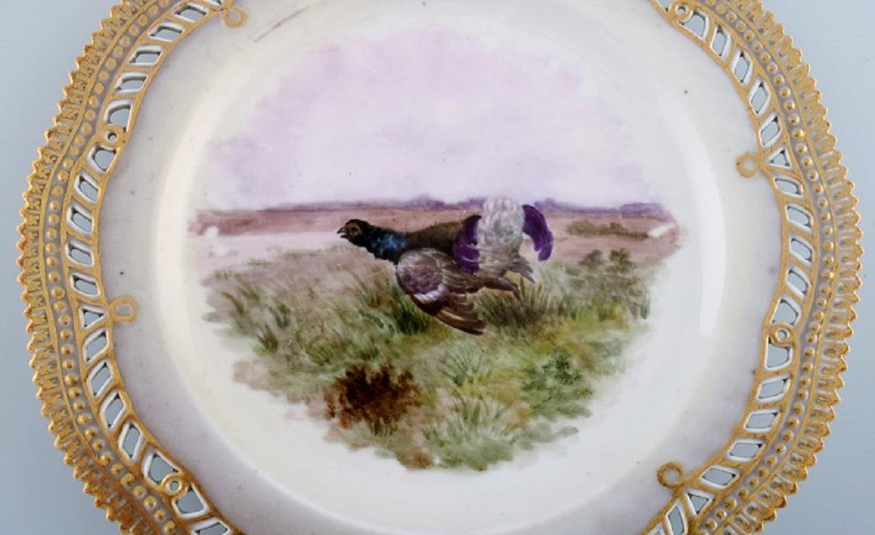Early and rare Royal Copenhagen Fauna Danica plate in hand-painted porcelain with hunting motif and gold decoration. 
19th century.
Diameter: 23 cm.
In excellent condition.
Stamped.
3rd factory quality due to the porcelain mass.