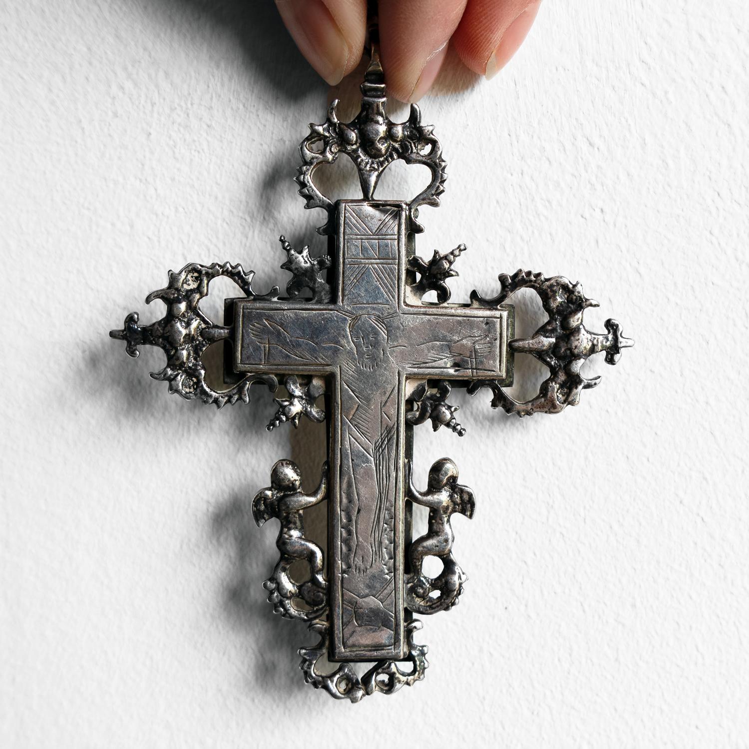 ANTIQUE SILVER CRUCIFIX/LATIN CROSS

A striking and decorative piece made from continental silver with a central crucifix engraved with a fairly naive depiction of Christ.

The central cross is surrounded by decorative silver embellishments in the