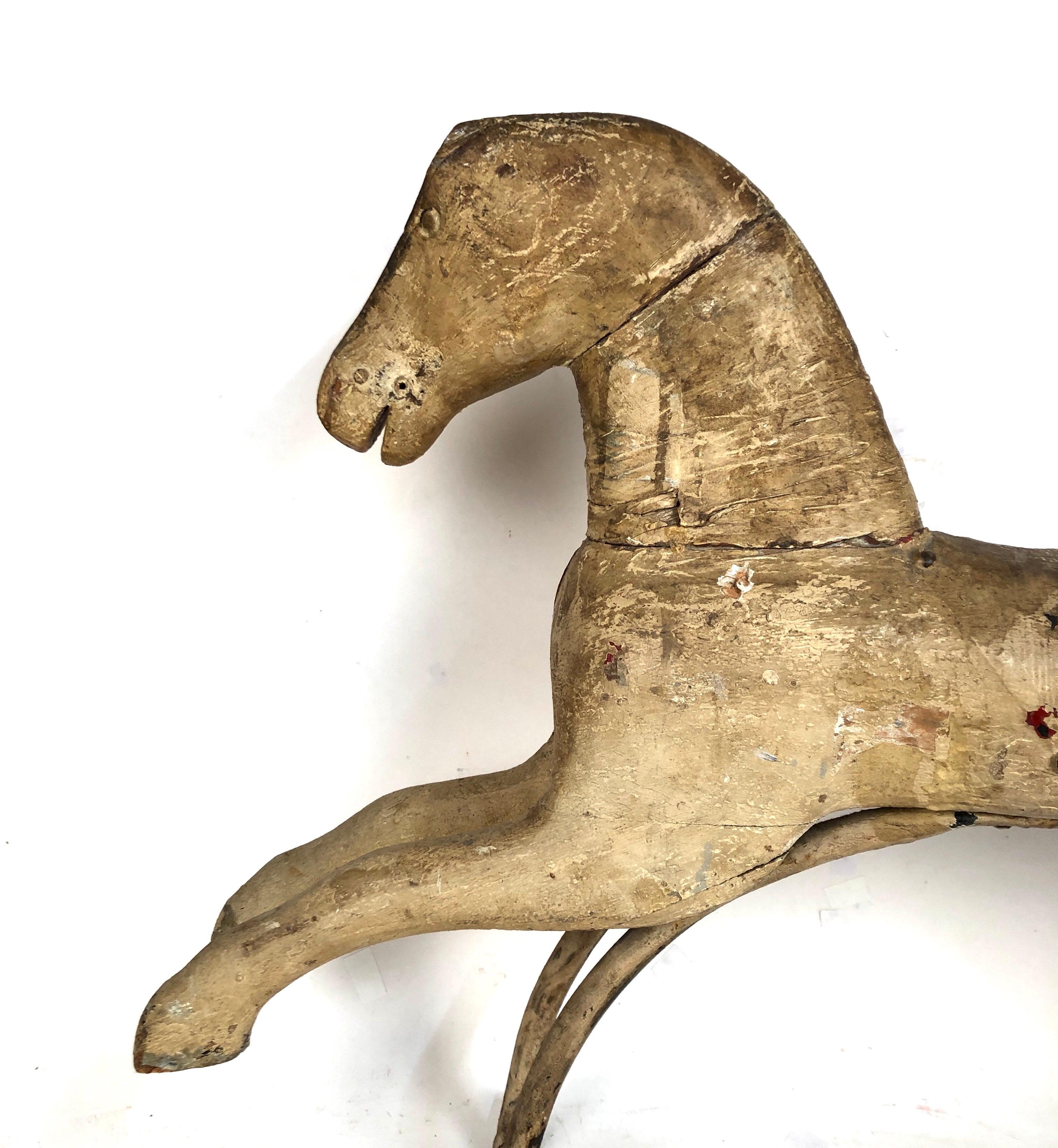 A very nice early antique wood rocking horse with old white paint. Still has the original metal rocking support. Great surface. Dates late 19th century. Great display item.