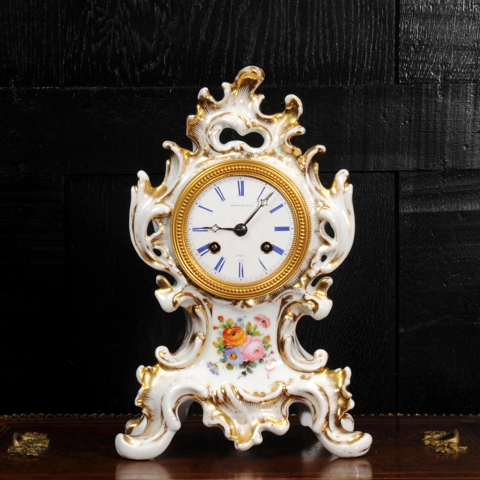Une très belle horloge en porcelaine de Samuel Marti. Magnifiquement conçu dans le style rococo, avec des volutes et un feuillage fluide. Délicatement décorée de bouquets de fleurs exquis et rehaussée de dorures.

Le cadran est en porcelaine