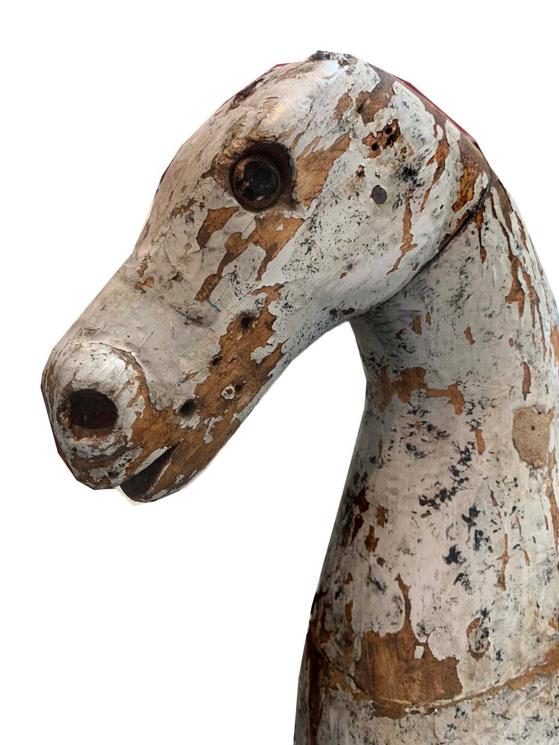 This is an amazing hand carved wood horse. Real original horse hair tail, primitive image, well constructed. Solid with original paint. A wonderful primitive horse with lovely age and form.