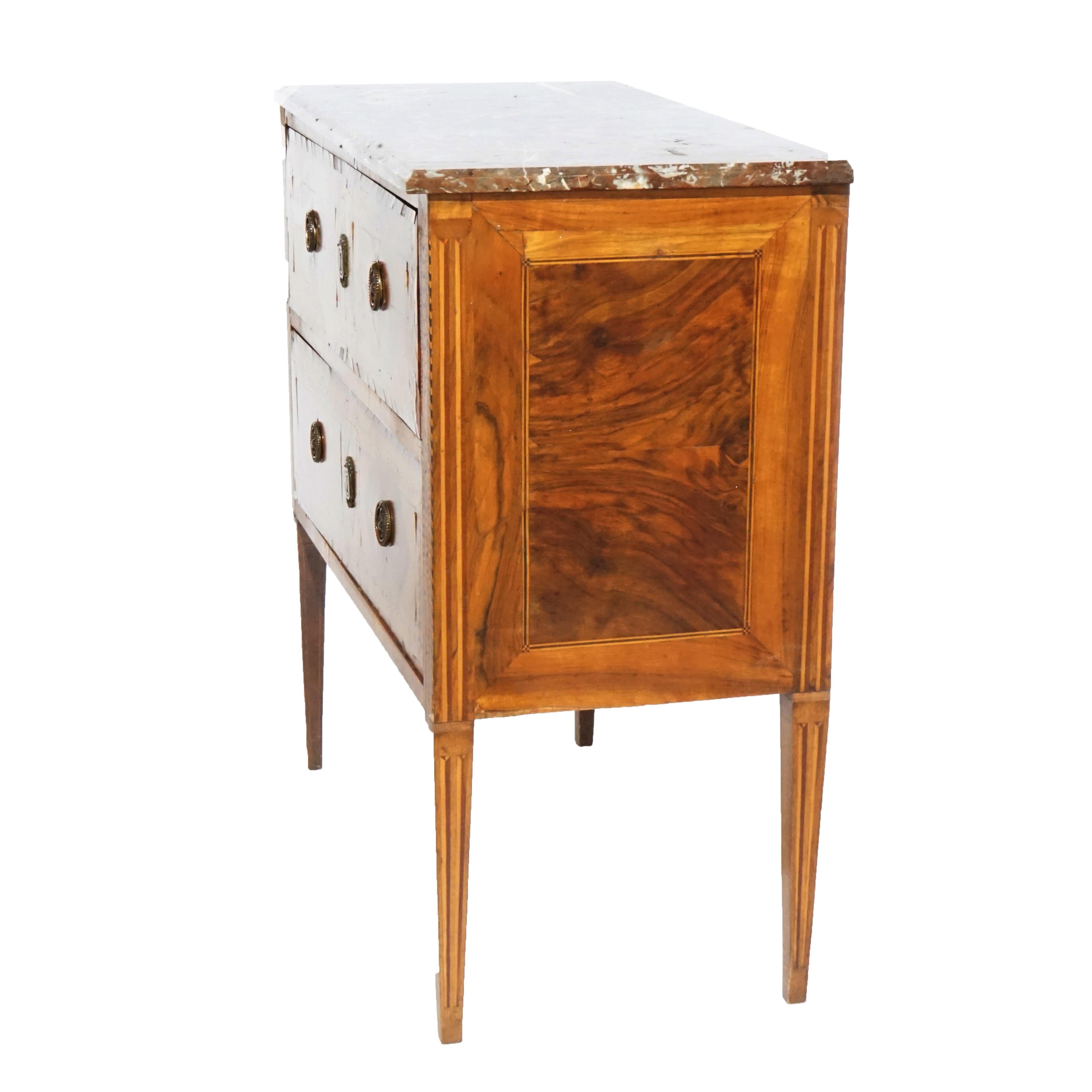 An early antique Italian commode offers specimen marble top over kingwood chest having two drawers, bookmatched facing, and satinwood inlaid banding; raised on square tapered legs, 18th century

Measures- 33.5''H x 33.5''W x 16.5''D.

*Ask about