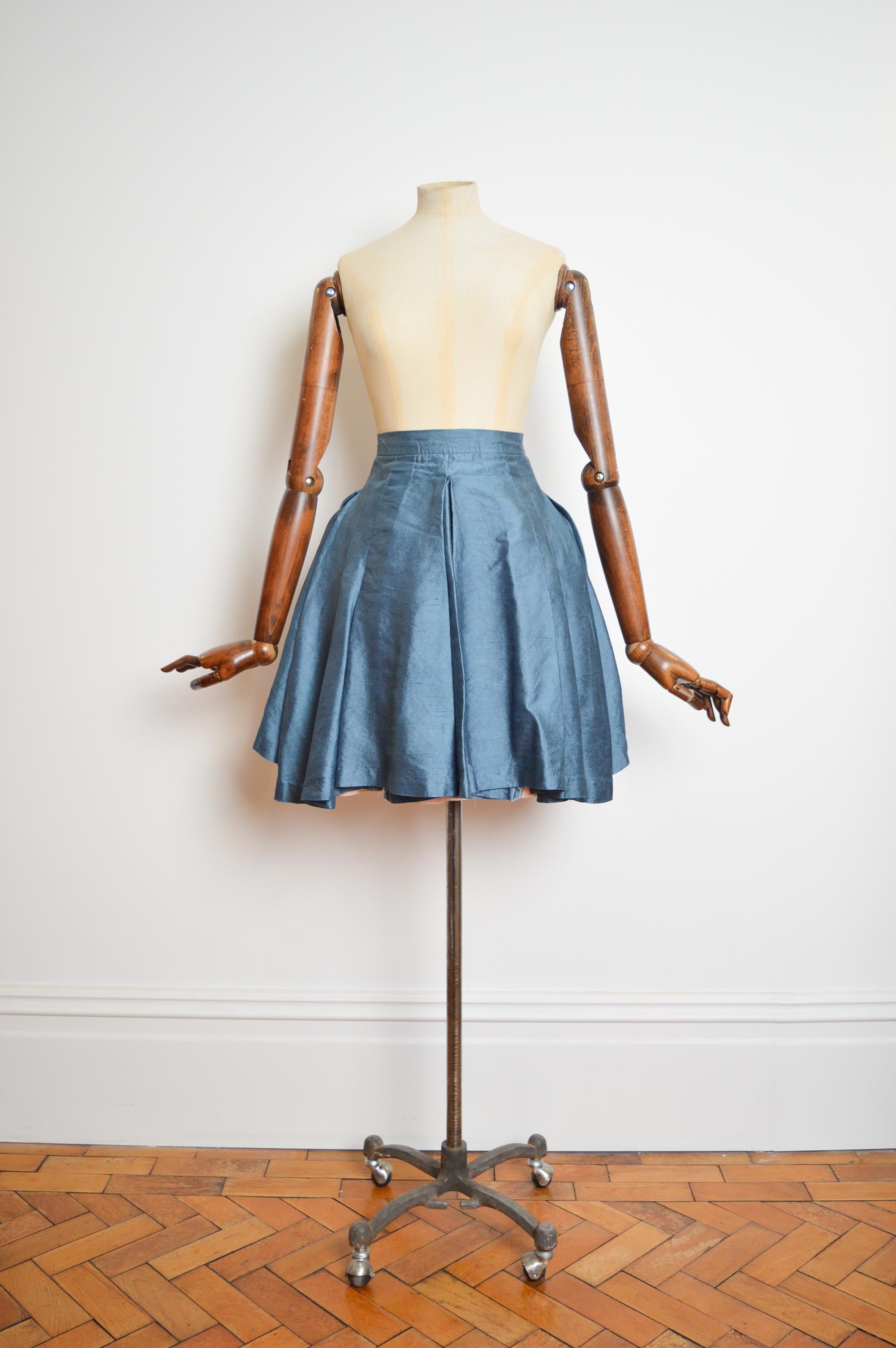 A Very Early, Museum worthy Vivienne Westwood Cornflower Blue silk mini skirt.
Circa 1980.

MADE IN ENGLAND.

Measurements are provided in Inches;
Waist; 22’’
Length; 21’’
Size; XXS ( We Would recommend a UK 4)
Condition; 7/10 please refer to