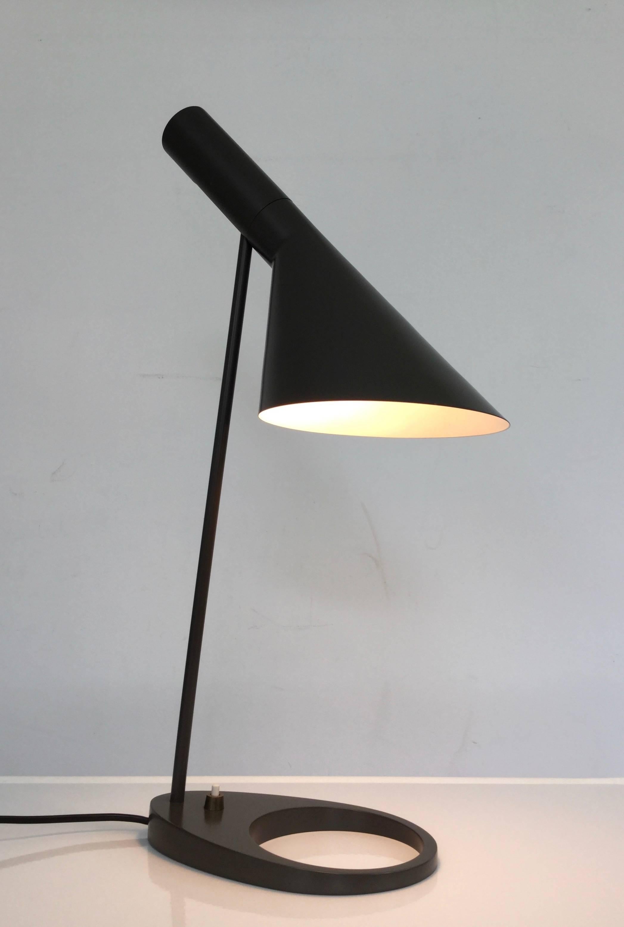 Arne Jacobsen AJ Visor table lamp by Louis Poulsen in distinct green-brown-grey color. 
Early example, recognizable by the brass switch on the base, in exceptional good condition. The true age of this lamp is only recognizable by the smaller