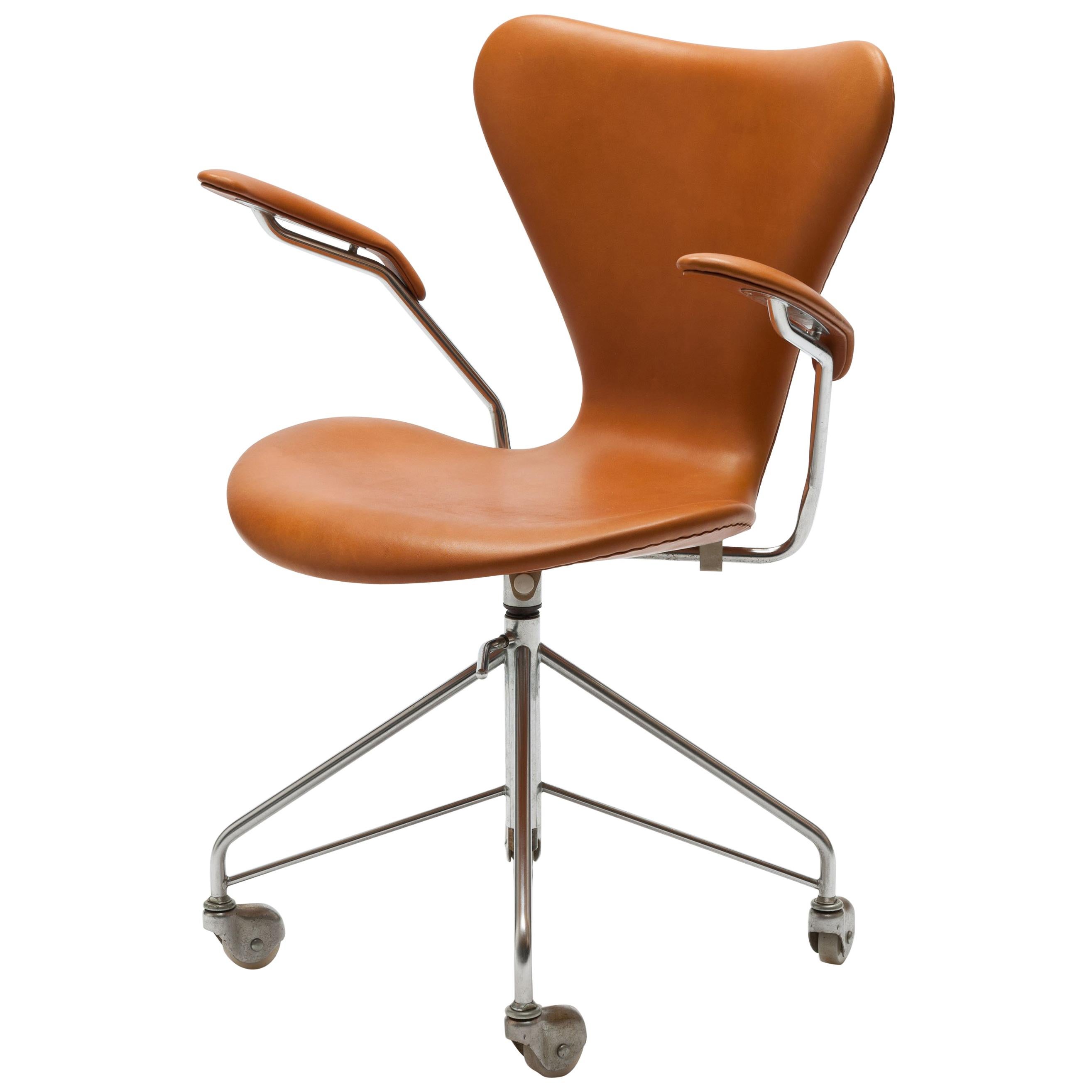 Arne Jacobsen swivel desk chair model 3217 office chair with armrests. Original, first series four-star swivel base with chromed steel feet on casters. Designed by Arne Jacobsen in 1955.
This chair dates from the early 1960s produced by Fritz