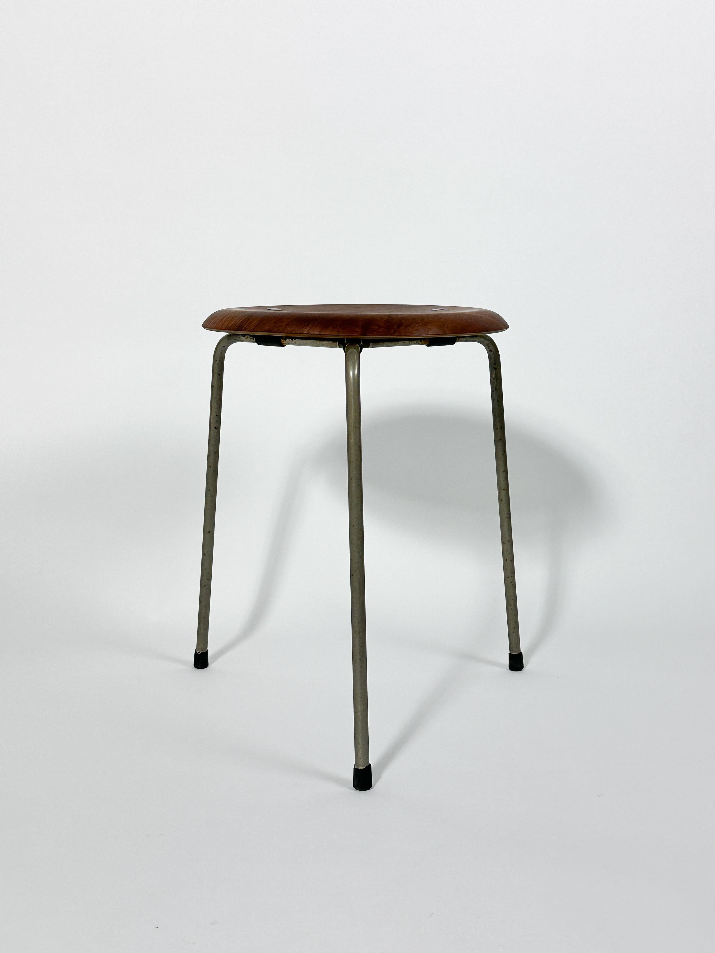Sgabello 'Dot' in teak di Arne Jacobsen di prima produzione, disegnato nel 1954 e realizzato da Fritz Hansen in Danimarca intorno al 1955-1956.

Bellissimo esemplare precoce con tre borchie in ottone sul sedile, pulito e rifinito con olio. Le gambe