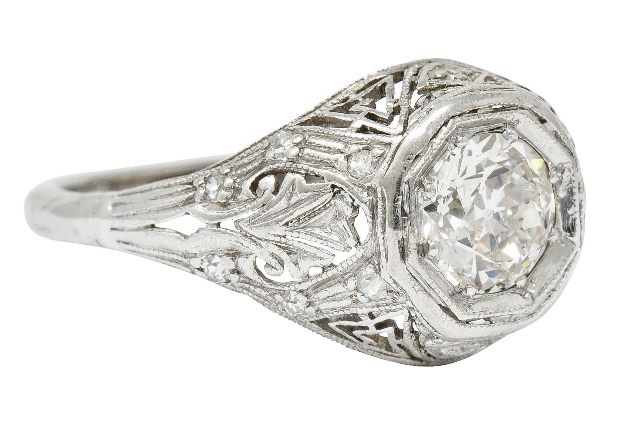Centering an old European cut diamond weighing approximately 0.60 carat; K with SI clarity

Set low in an octagonal head of an intricately pierced mounting featuring foliate shoulders and Greek key design

Accented by single cut diamonds weighing