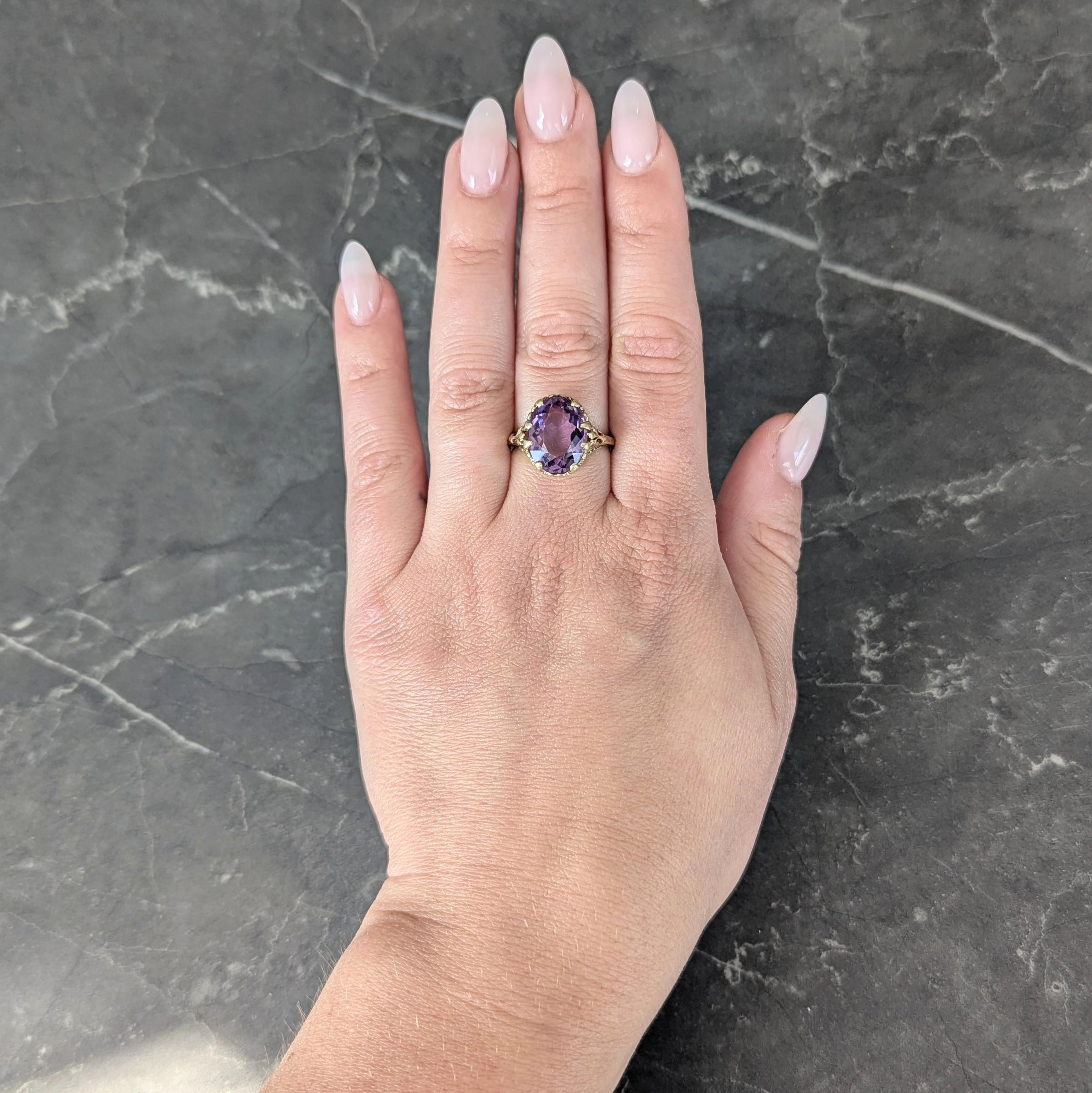 Centering an oval shaped amethyst weighing approximately 4.85 carats
Transparent medium purple in color and set with wide prongs
Accented by a scrolling heart motif filigree gallery profile
Flanked by split fleur-de-lis shoulders
Stamped for 14