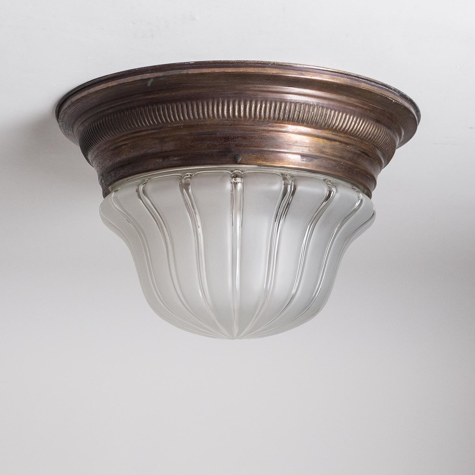 Fine Art Deco flush mount, circa 1910. Patinated brass hardware with an elegantly shaped glass diffuser with a striped satin finish. Nice original condition with patina on the brass. One original brass and ceramic E27 socket with new wiring.