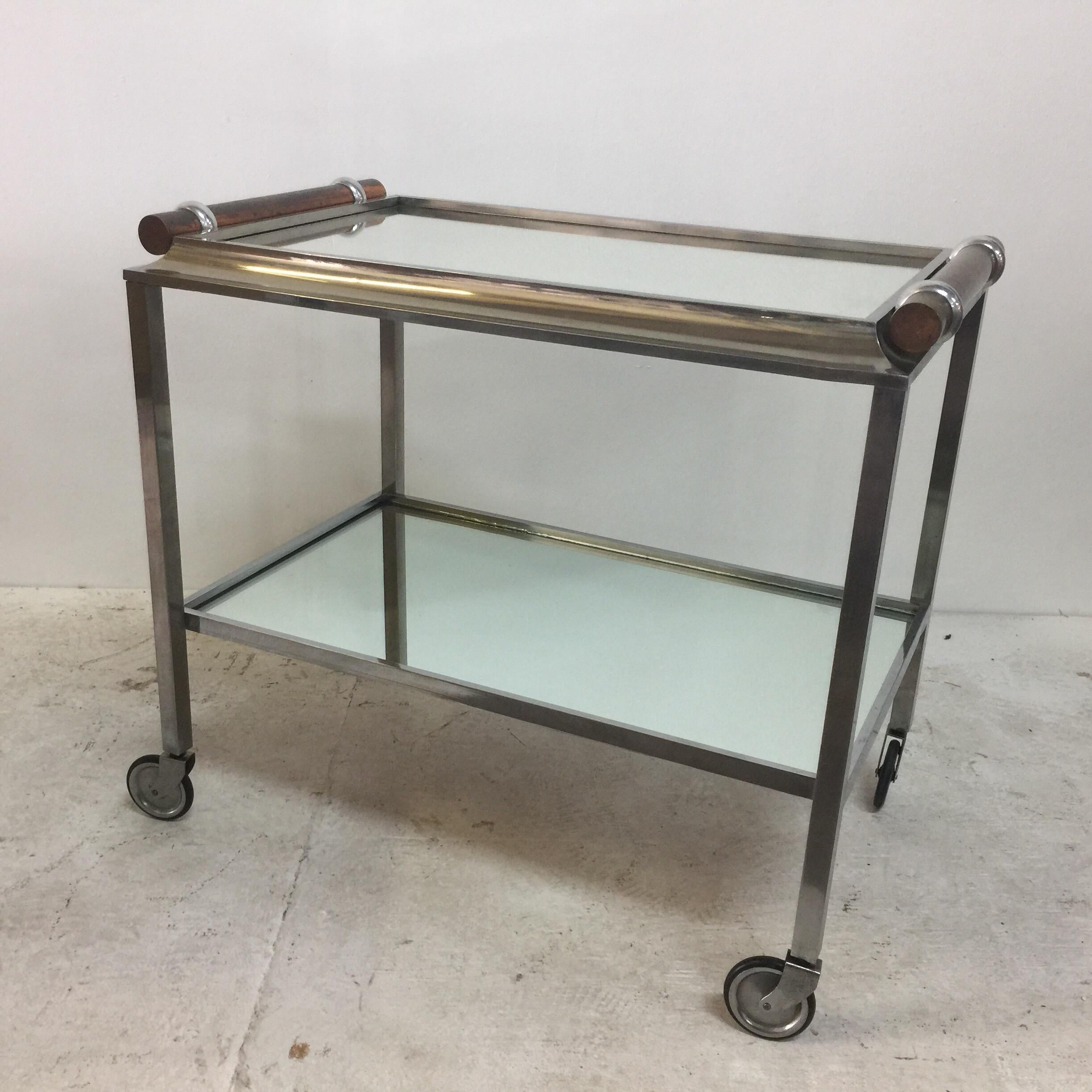 This beautiful two-tiered tea or bar cart with original mirror shelves and copper handles. The cart is on casters and in good working condition. Very sleek and elegant. The tray top is not removable.