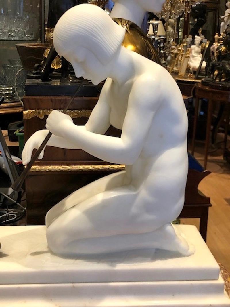 Magnificent early Art Deco white Marble female figure of a Snake Charmer “Charmeuse de Serpent” By Guglielmo Pugi, 

The naked snake charmer kneels upon a carved pattern rug, whilst leaning forward towards the snake, on a Marble base, with bronze