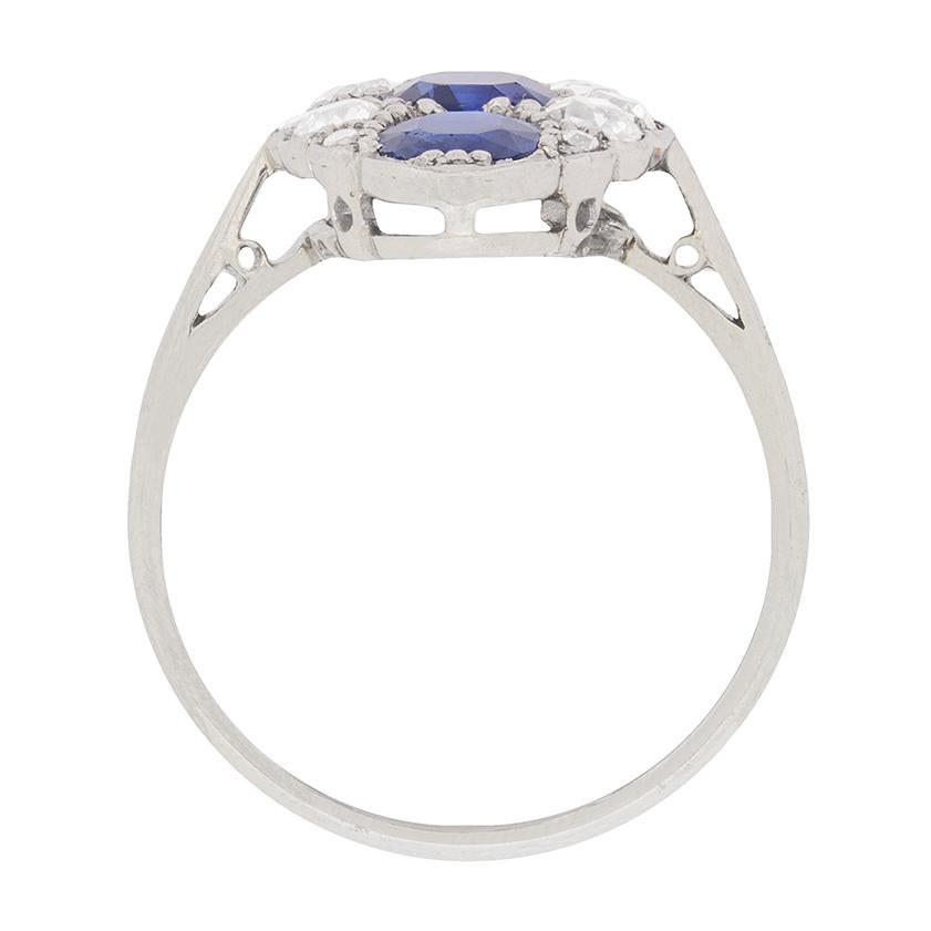 This beautiful ring boasts wonderful blue sapphires set in perfect harmony with a collection of old cut diamonds. The sapphires, which are natural, are rub over set vertically, down the centre of the piece. The centre stone weighs 1.15 carat, and