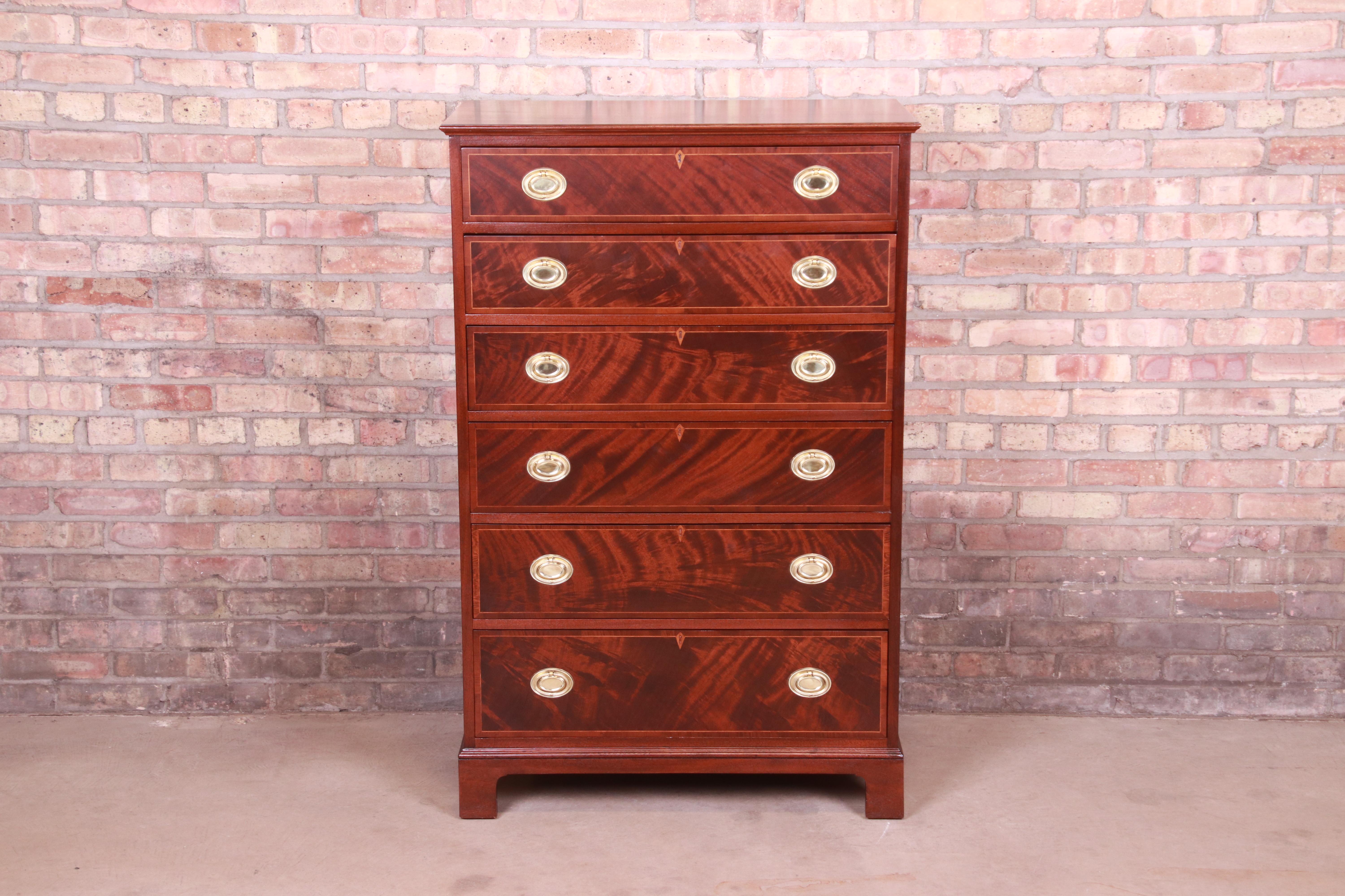 A gorgeous Georgian style six-drawer highboy chest of drawers

By Baker Furniture

USA, Circa 1930s

Book-matched flame mahogany, with satinwood string inlay and original brass hardware.

Measures: 32