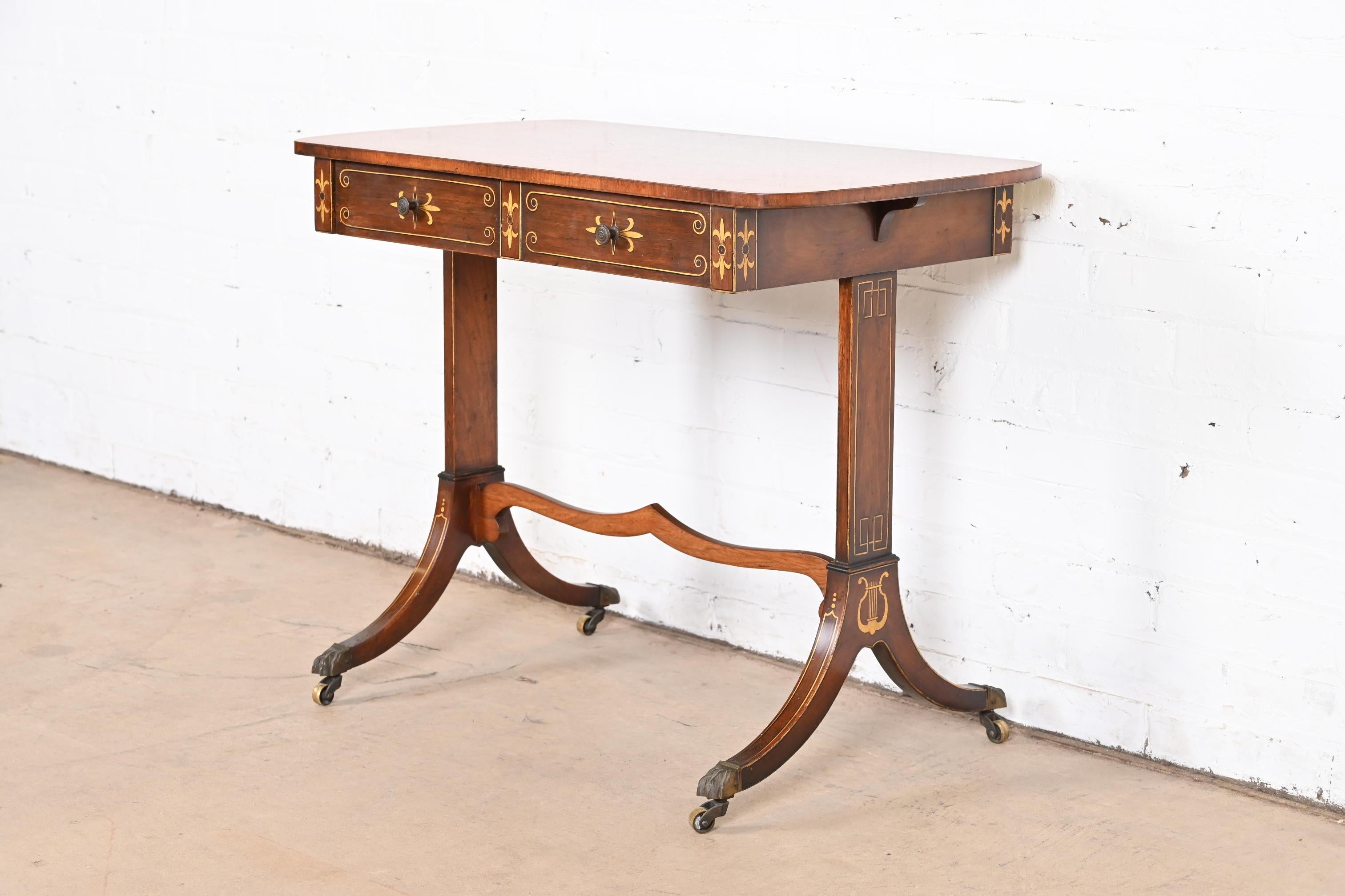 A gorgeous Regency style petite writing desk, sofa table, or entry console table

By Baker Furniture

USA, Circa 1930s

Rosewood, with hand-painted details, brass hardware, and brass paw feet on castors.

Measures: 30