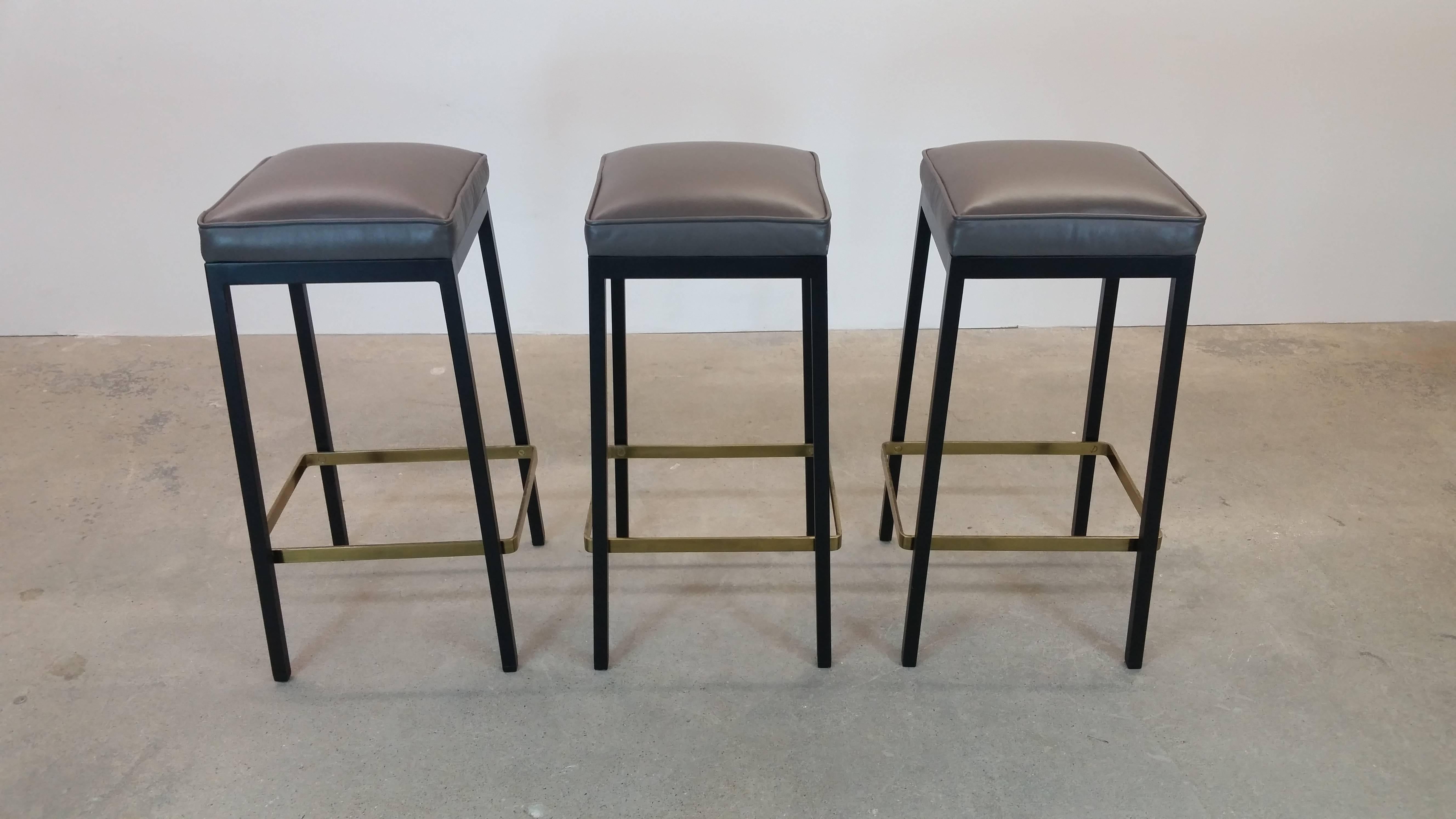 Bar stools designed by Florence Knoll, and produced by Knoll Associates, circa 1952. Tops newly upholstered in top quality medium grey leather.