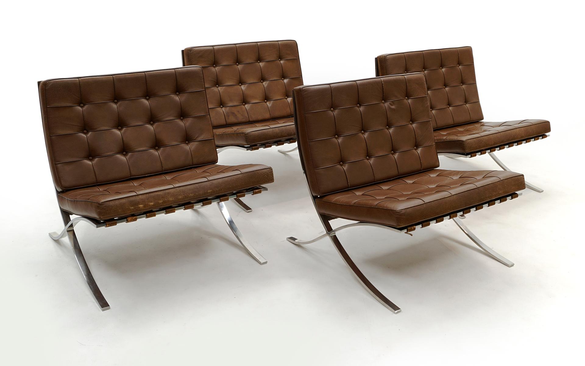 Four Early original 1960s production Barcelona chairs designed by Ludwig Mies van der Rohe for Knoll. Brown leather with solid stainless steel frames. Not the chromed steel version, but the much more desirable stainless steel version. These are the