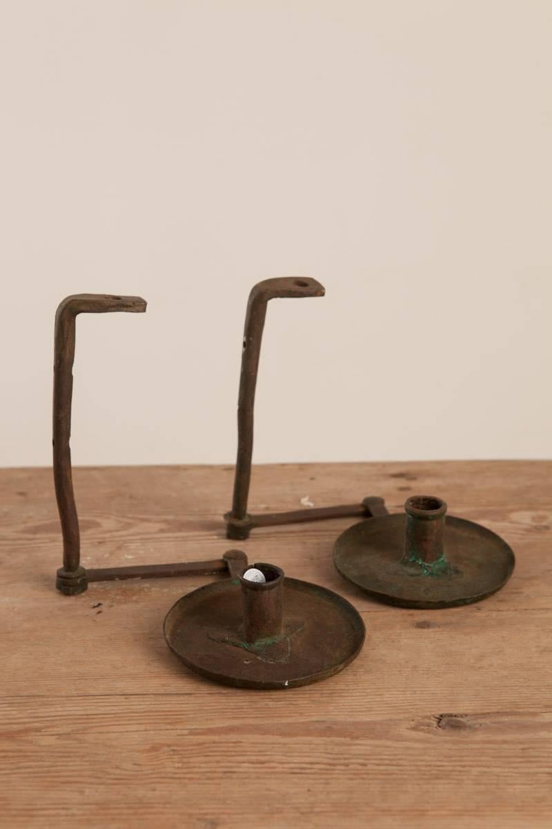 An amazing pair of early Baroque 18th century iron candleholders / sconces, pair, origin: Sweden, circa 1700, they are finished and gorgeous from every angle. 

See the photograph, these sconces hang from the top of the sconce and can be mounted