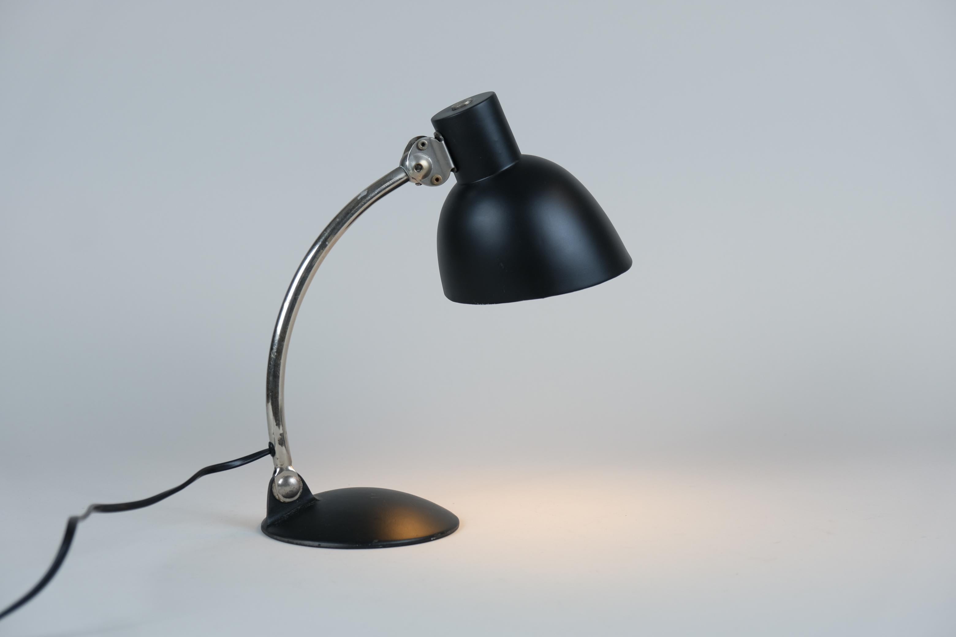 Cette lampe de table fait partie des premières lampes Tynell des années 1930 avec une influence évidente du Bauhaus. La combinaison de la peinture noire et du pied chromé distingue cette lampe des lampes en laiton courantes dans ses créations