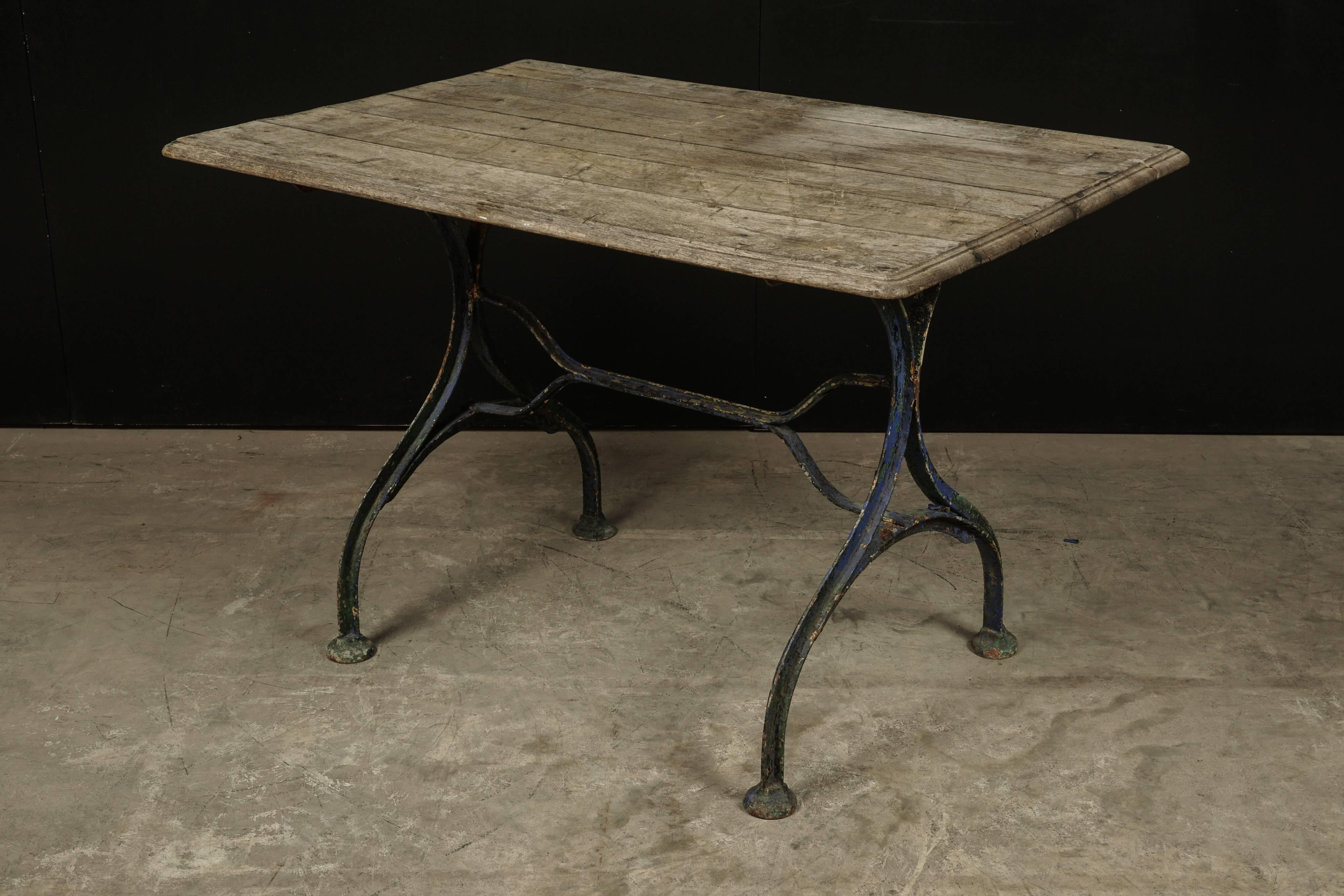 Early bistro table from France, circa 1920. Oak top with an iron base in original blue paint.
