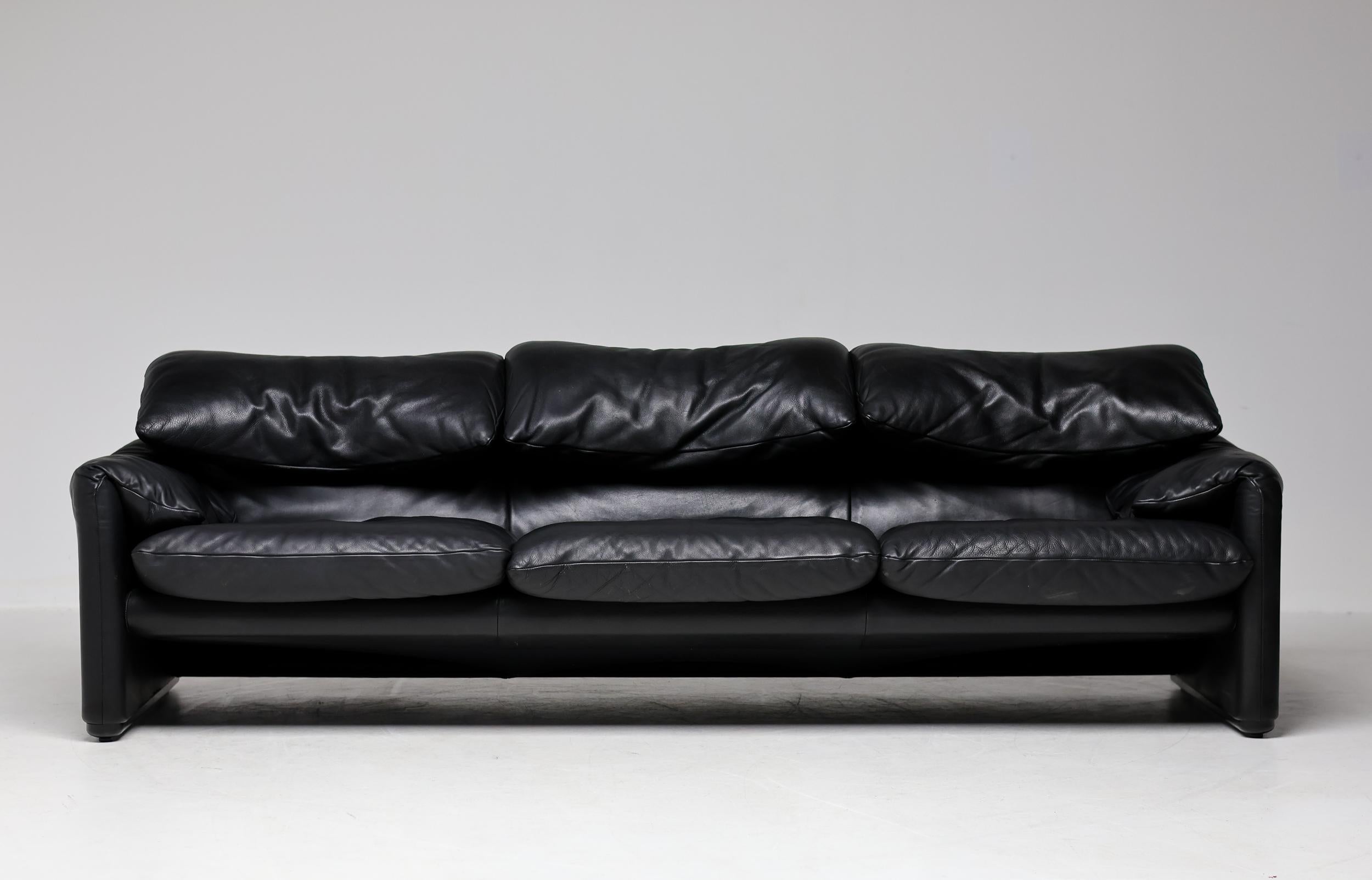 Desirable early Maralunga 3-seat Sofa in black leather, designed in 1973 by Vico Magistretti for Cassina. 
This sofa features back rests cushions that can be folded up or down. The effect is a sofa that serves two functions: It’s both a backdrop for