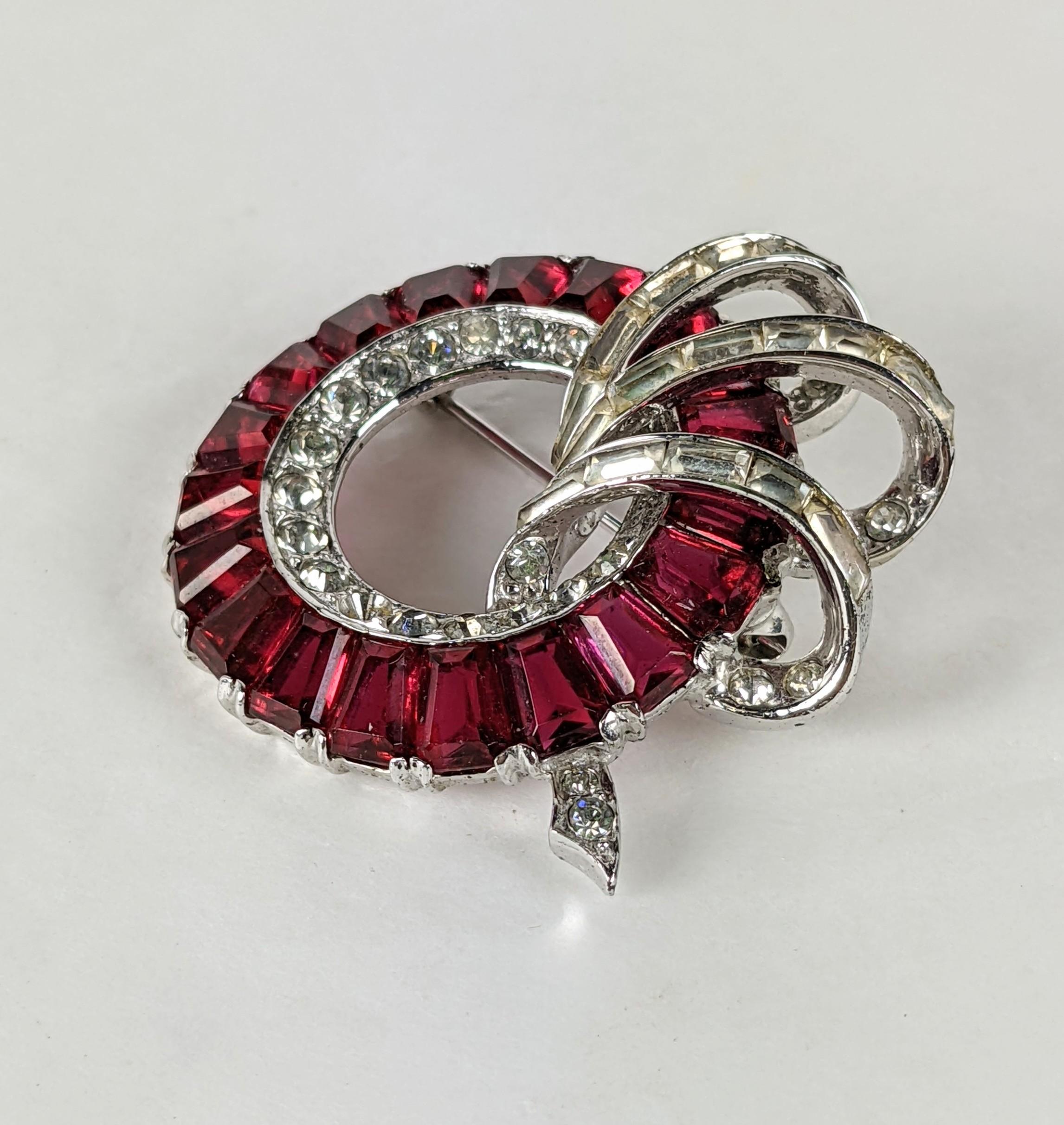 Early Boucher Channel Set Brooch in sterling with rhodium plate finish. Faux rubies are channel set in a wreath form with sprays of pave baguettes. Marked 