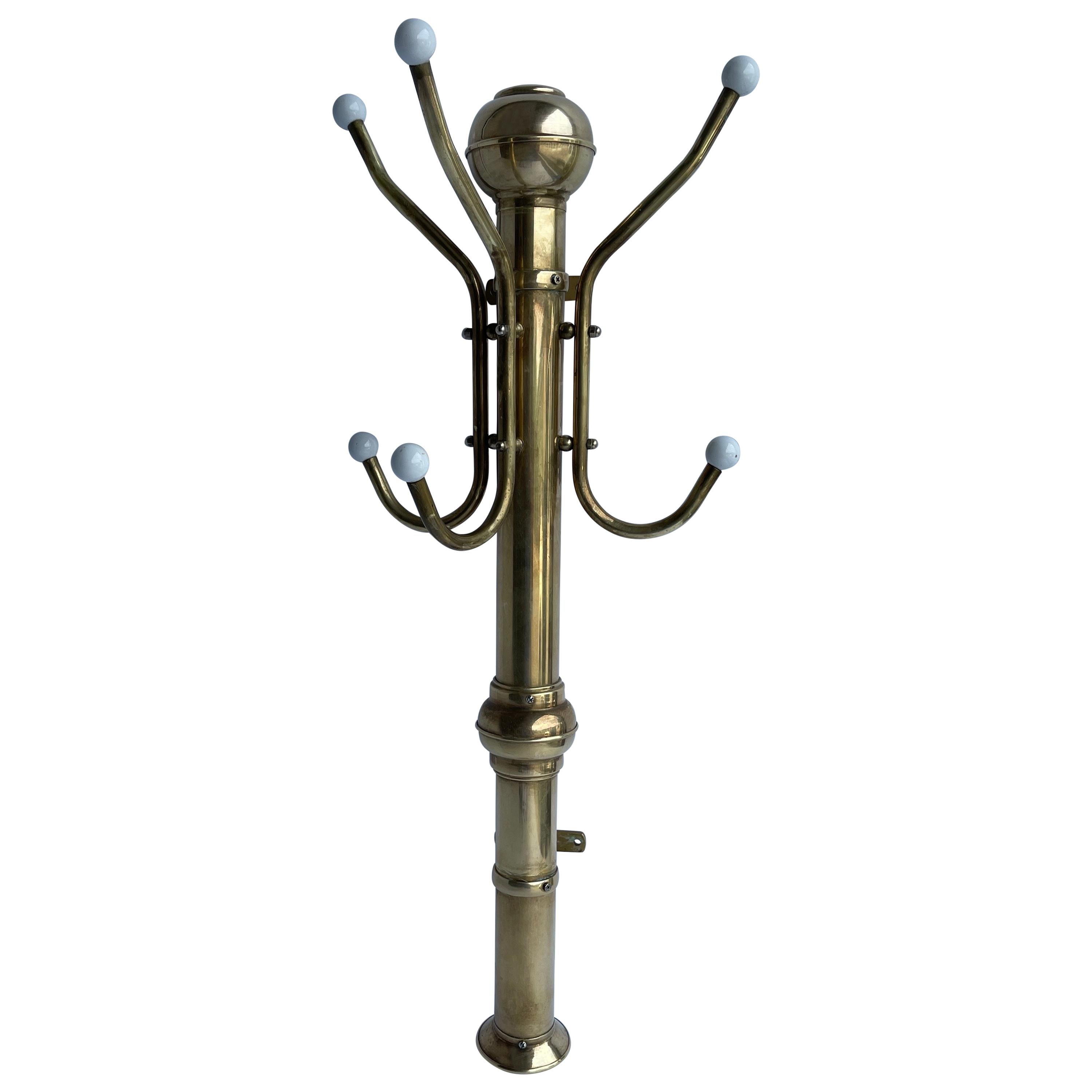 Early 1900's brass and Porcelain coat and hat wall mounted rack.
This sturdy coat and hat rack is a wonderful example of vintage design functionality. These racks were common in a variety of venues. They are sturdy, functional and classic. The