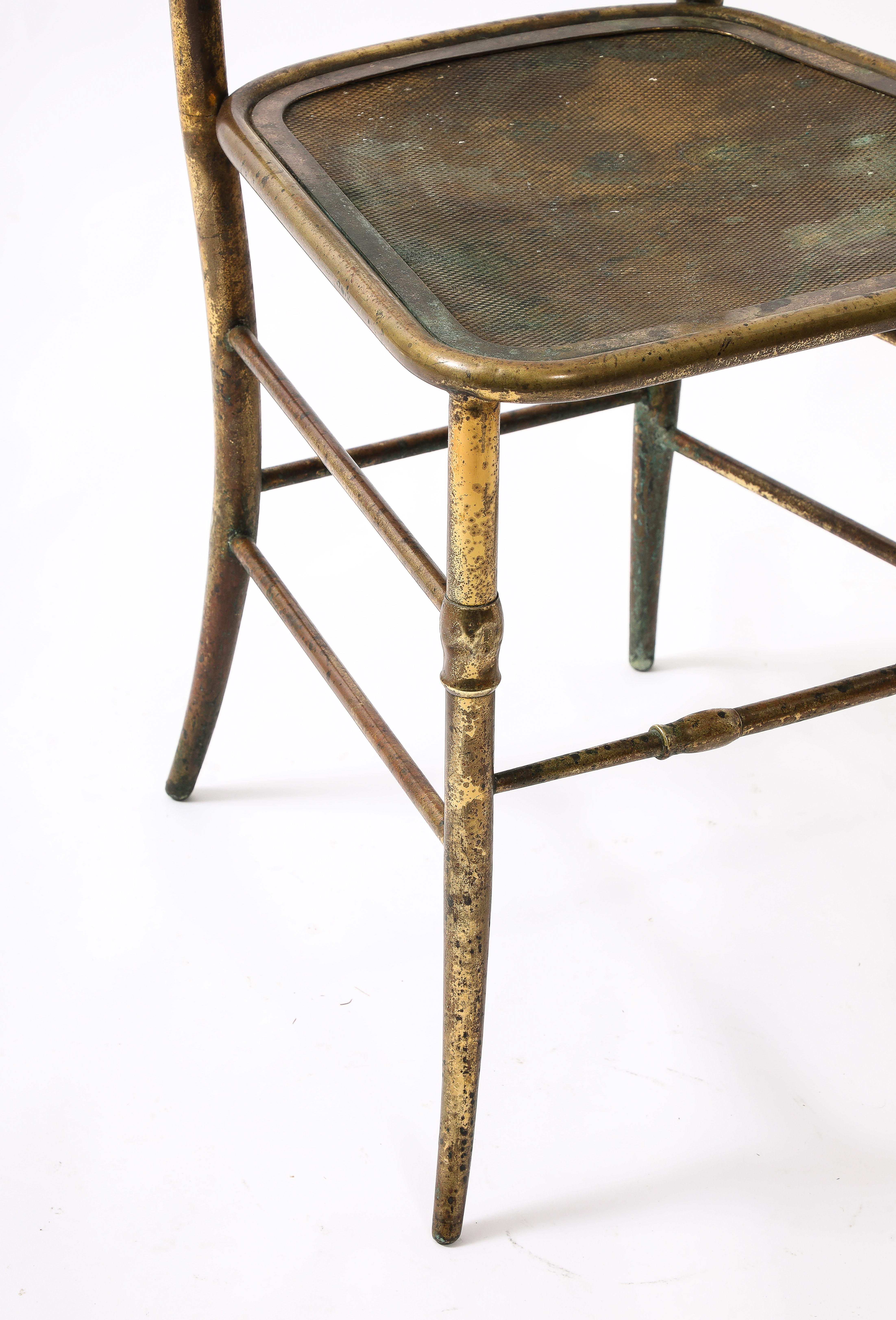 A very early Charivari chair, it is made of cast hollow brass elements silver welded together unlike the later solid brass ones, more unusual is its pierced brass seat, most likely made for use on a covered patio, a rare find with a wonderful patina.