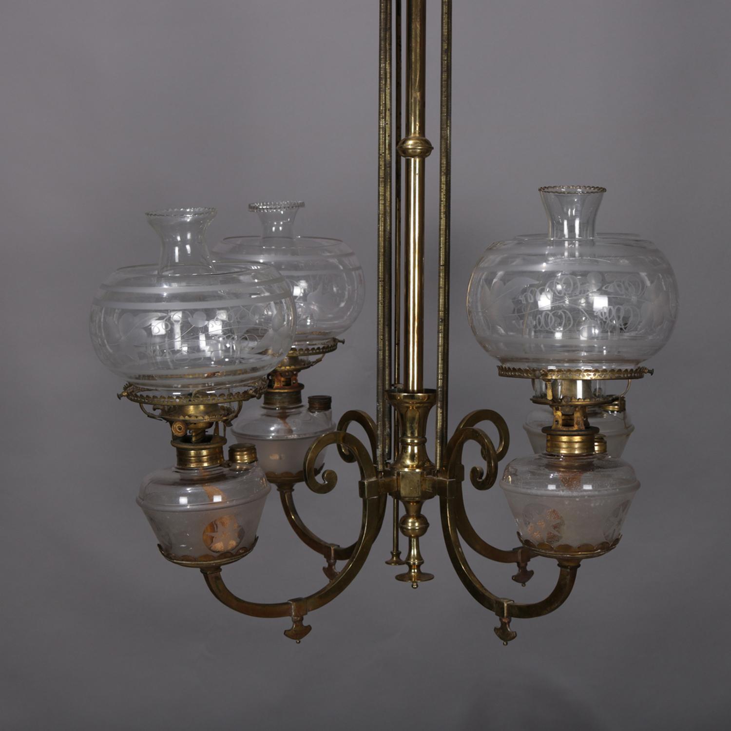 An early kerosene chandelier features brass frame with central column having four c-scroll arms terminating in gas lamps with glass fonts and etched glass shades, circa 1870.

Measures: 36