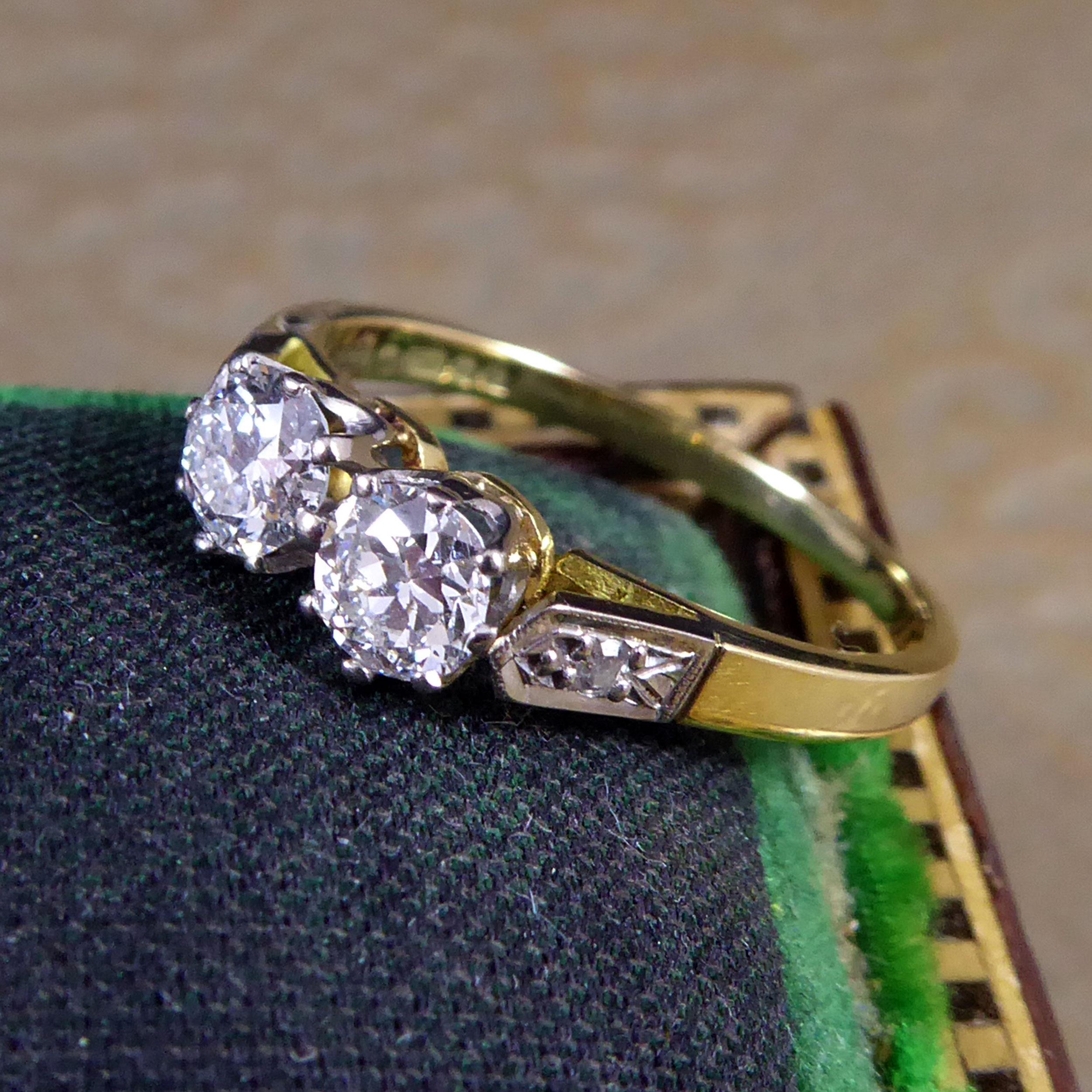 Ein ungewöhnlicher Diamantring mit zwei Steinen, besetzt mit einem Paar früher Diamanten im Brillantschliff in weißer Krallenfassung.  Der Gewicht eines Diamanten wird auf 0,32 Karat geschätzt und die Farbe und Reinheit werden als G/H und I1