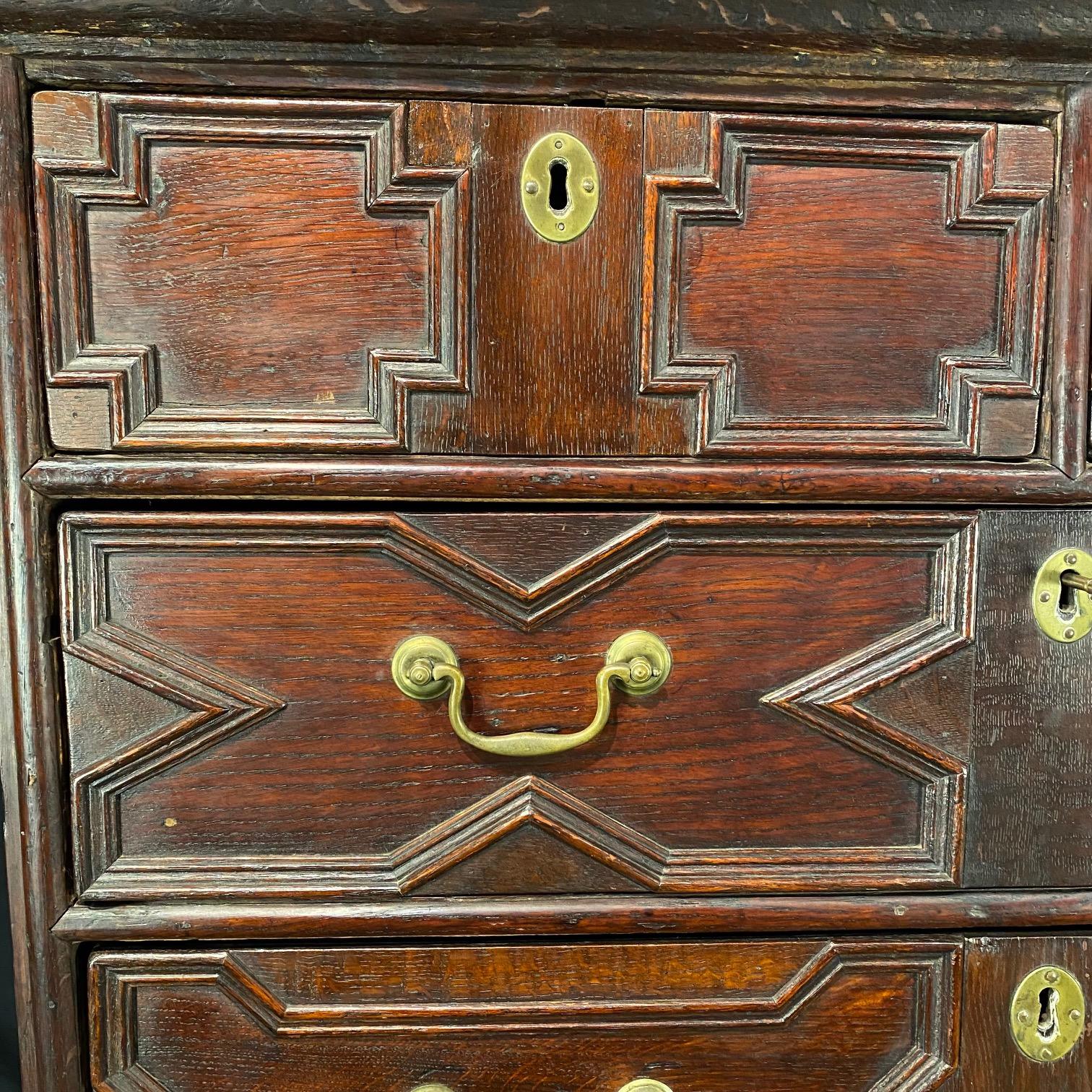 Cómoda de roble inglés Carlos II sobre peana, en dos partes, con su cajonera sobre un precioso bastidor de base de camilla torneada, la sección superior con dos cajones de más de tres cuarterones con molduras geométricas, la base de camilla con