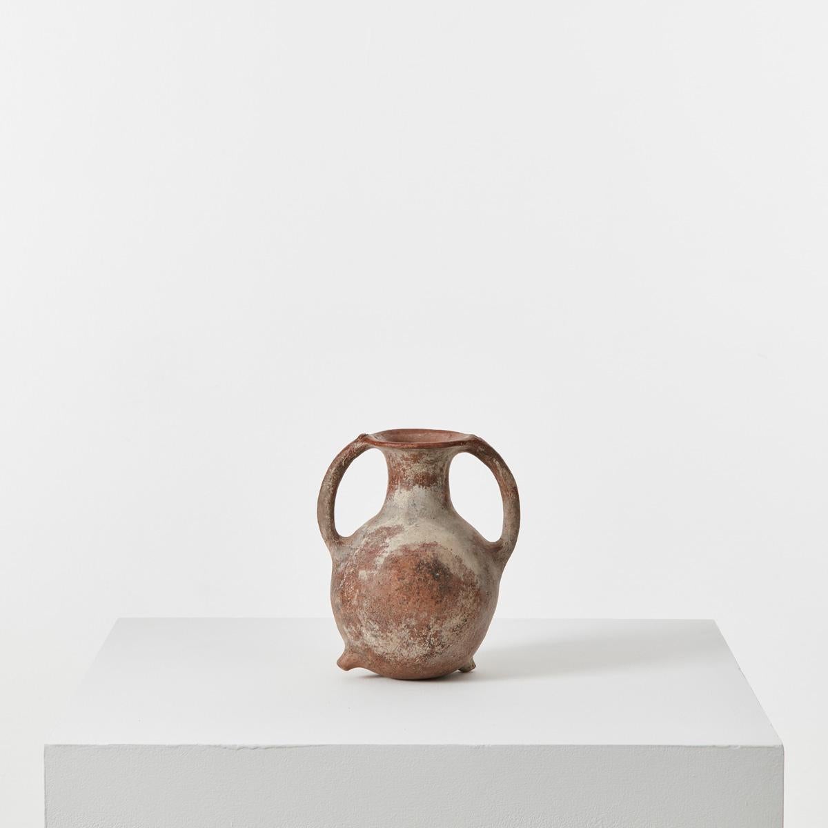 This ancient ‘neck amphora’ is full of character, with two asymmetrical nipples or
protrusions on its base and raised decorations at the top of its handles. Crafted 4,000 years ago, it has aged beautifully, and is stippled with pale pink and