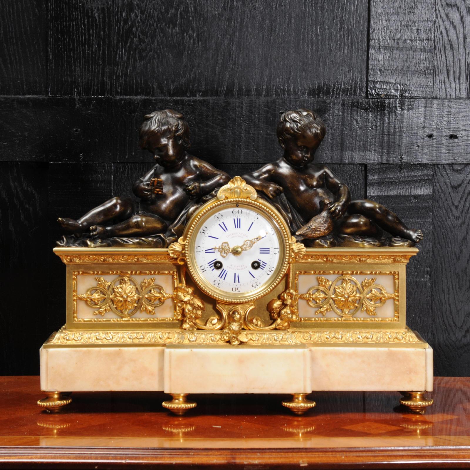 A beautiful early clock by the famous bronze founder Charpentier of Paris, circa 1840. It features two Putti, one playing the pipes and one holding a dove, emblematic of love. Both are finely modelled in bronze with a lovely antique patina. They are