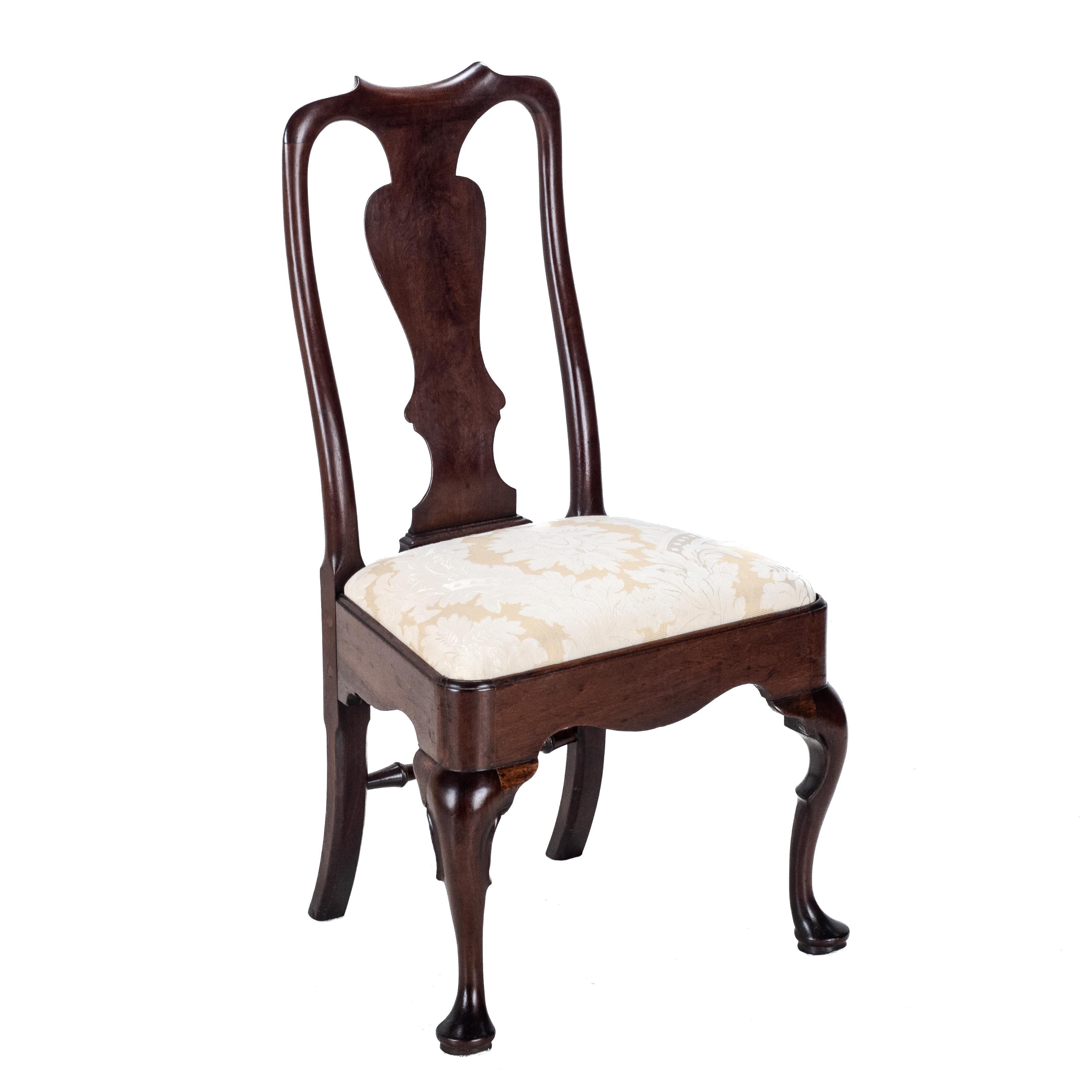Chaise d'appoint du début du C.C.A., dans le style Queen Anne, vers 1720, période George I. C.  Fabrice est doté d'un dossier vasiforme massif, surmontant une assise à hauteur d'homme recouverte d'un tissu de brocart de couleur or et ivoire. Elle