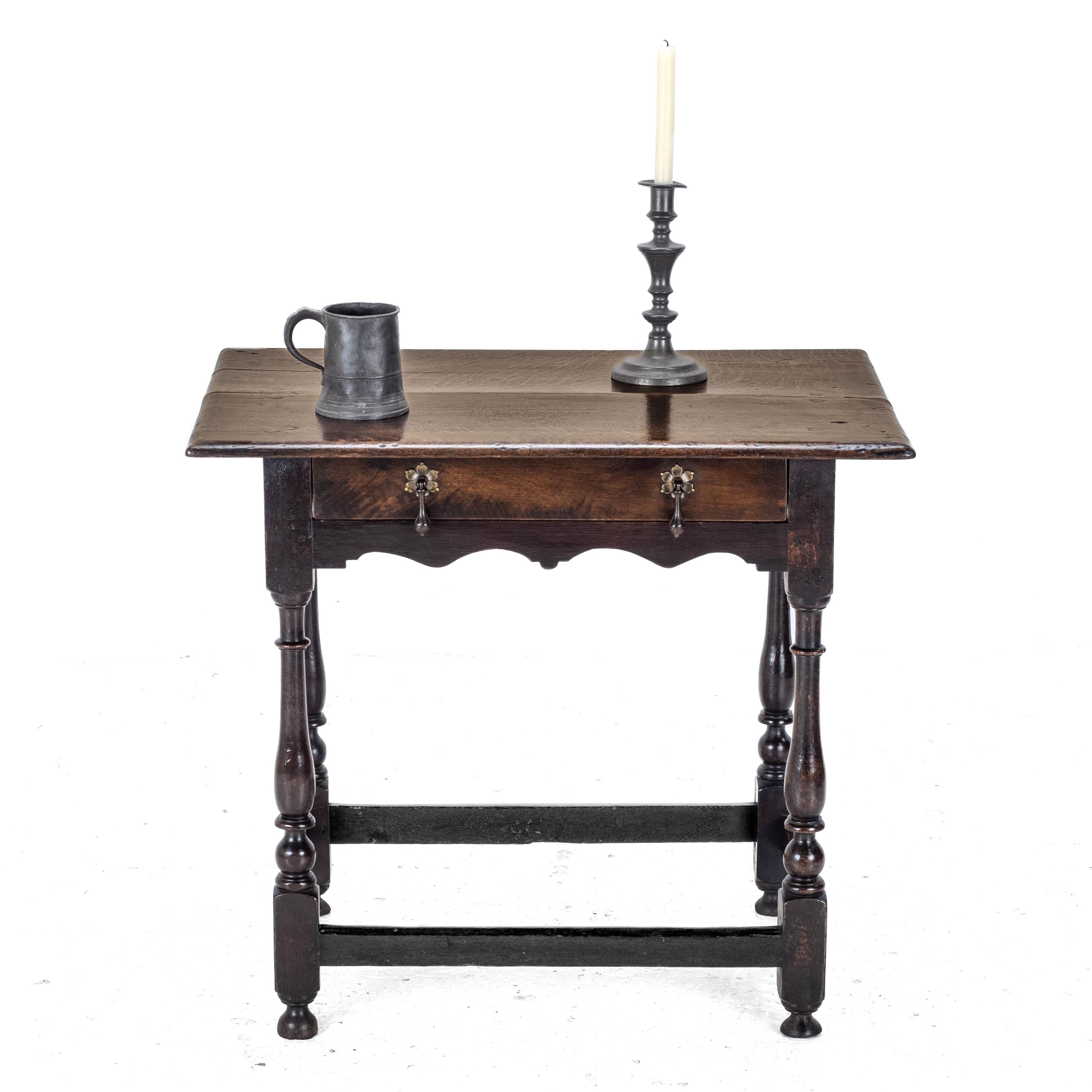 Table d'appoint en chêne du début du 18e siècle. La construction en chêne massif est omniprésente. Planche de forme oblongue avec bord semi-rond. La frise comporte un seul tiroir sur toute la largeur avec deux poignées en laiton, un tablier