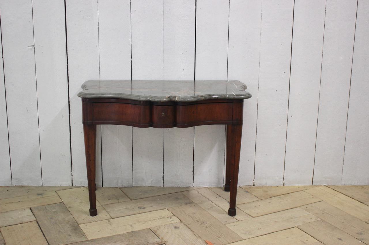 A good quality and with a lovely color, early 19th century Italian mahogany serpentine console table, of elegant proportions retaining the original marble top and with curved sides.