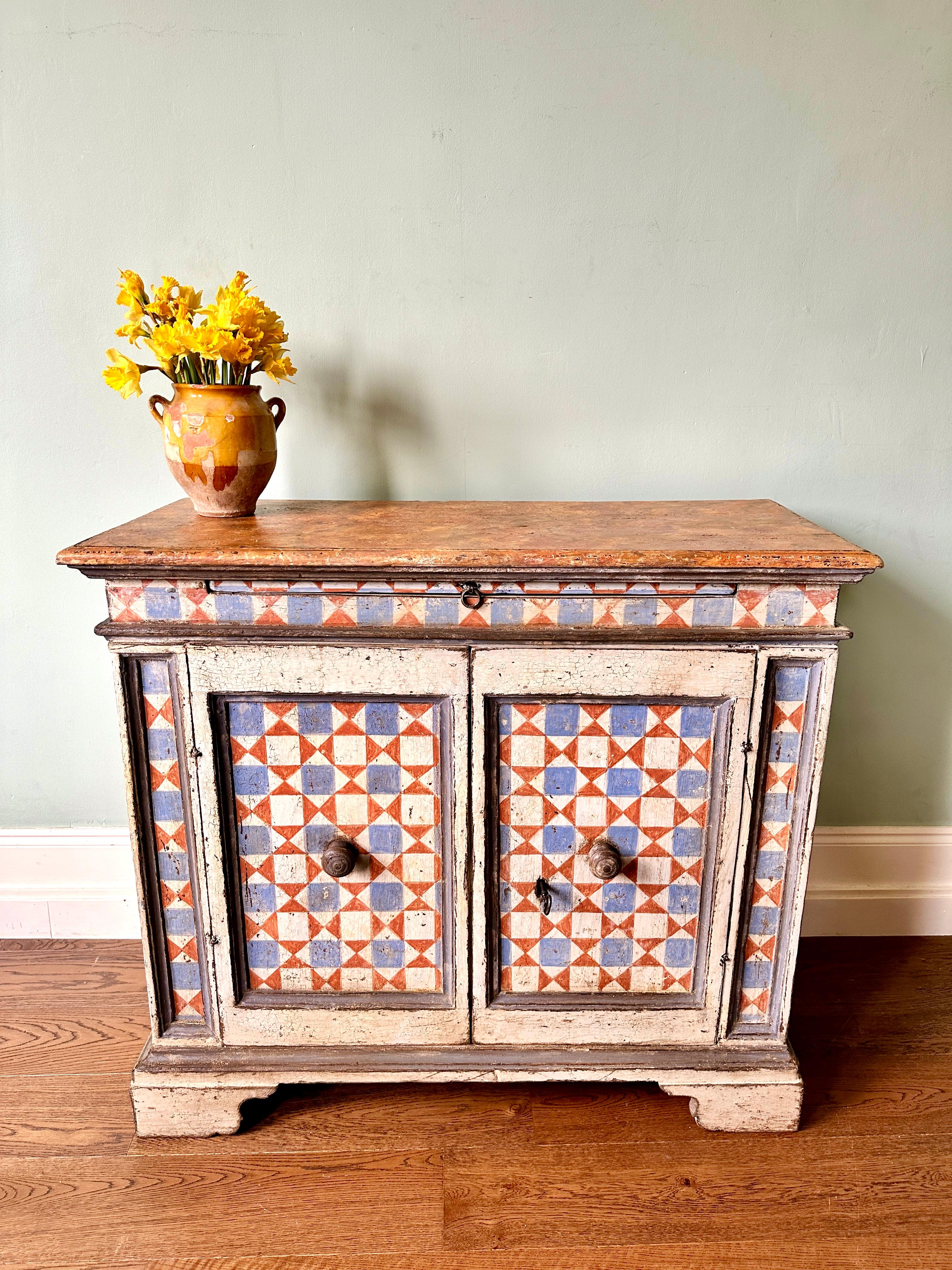 Early C19th Italian painted credenza.

Exceptional geometric hand-painted pine sideboard with cupboard storage and extendable shelf. In very good condition with original lock, key and door hook. Wonderful and desirable wear consistent with age and