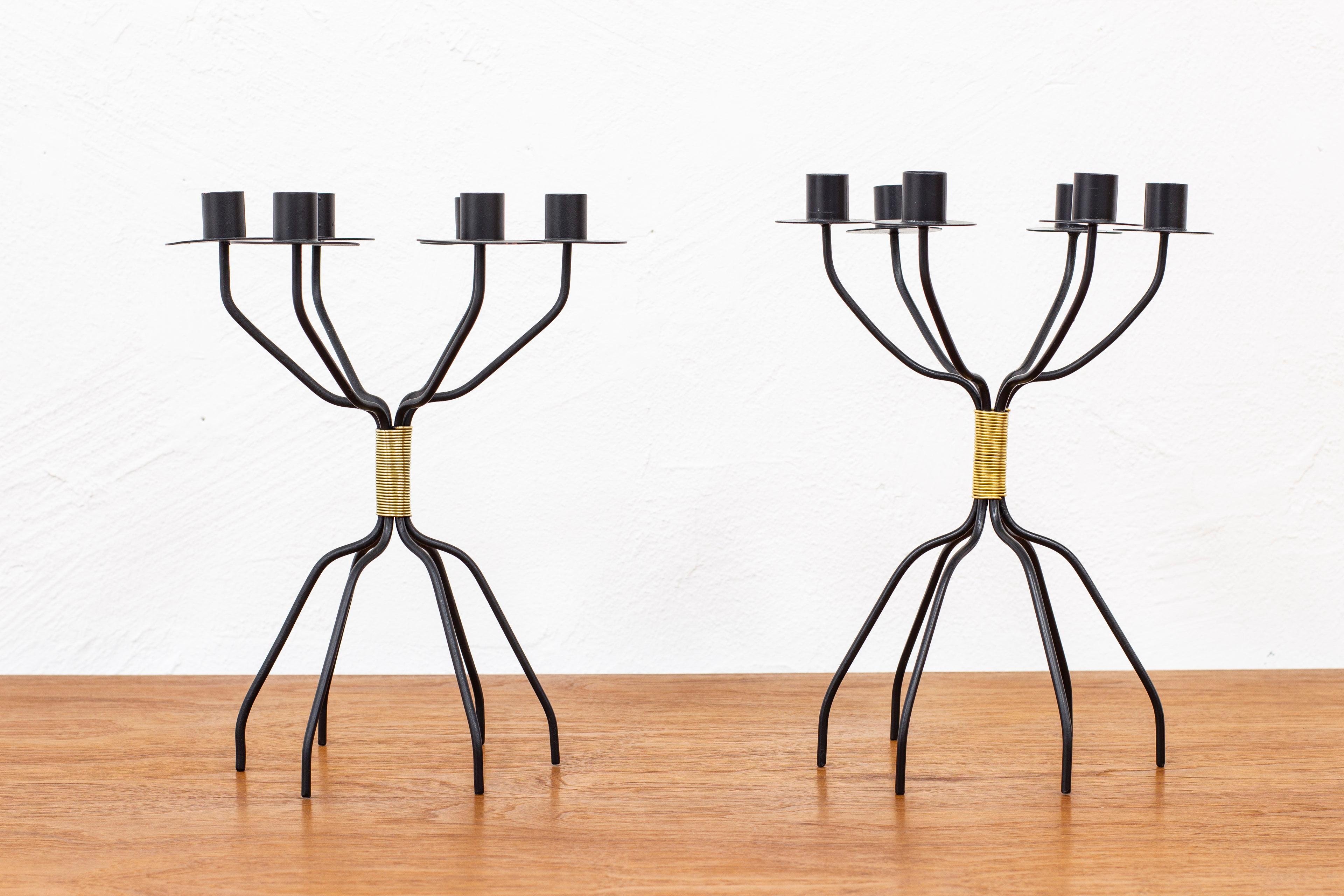 Pair of early and rare candelabras designed by Hans-Agne Jakobsson. Hand made in his first workshop in Åhus, Sweden during the early 1950s. Made from black lacquered metal and brass wire. Both candelabras Have six candle holders and legs but vary