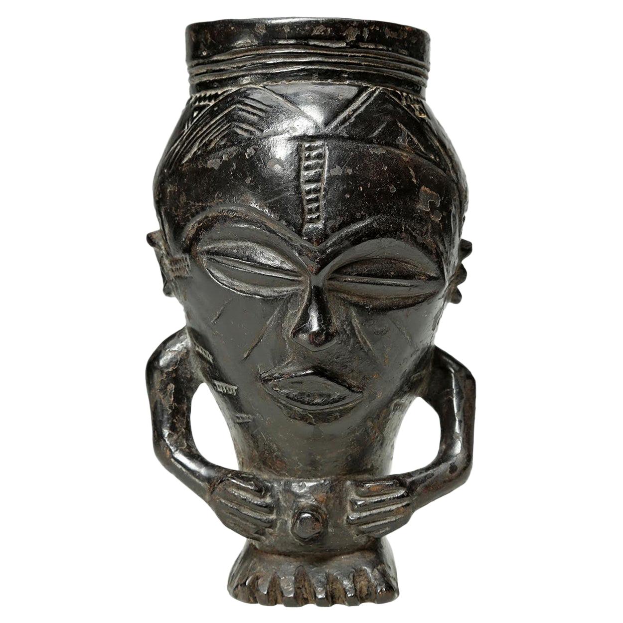 Early finely carved wood tribal Kuba figural cup, Congo with rich dark patina. In the form of a stylized figure with hands on stomach, ending on a foot. Deep patina from extensive use, early 20th century. Measures: Cup 8 x 4 1/2 x 4 1/2 inches. Kuba