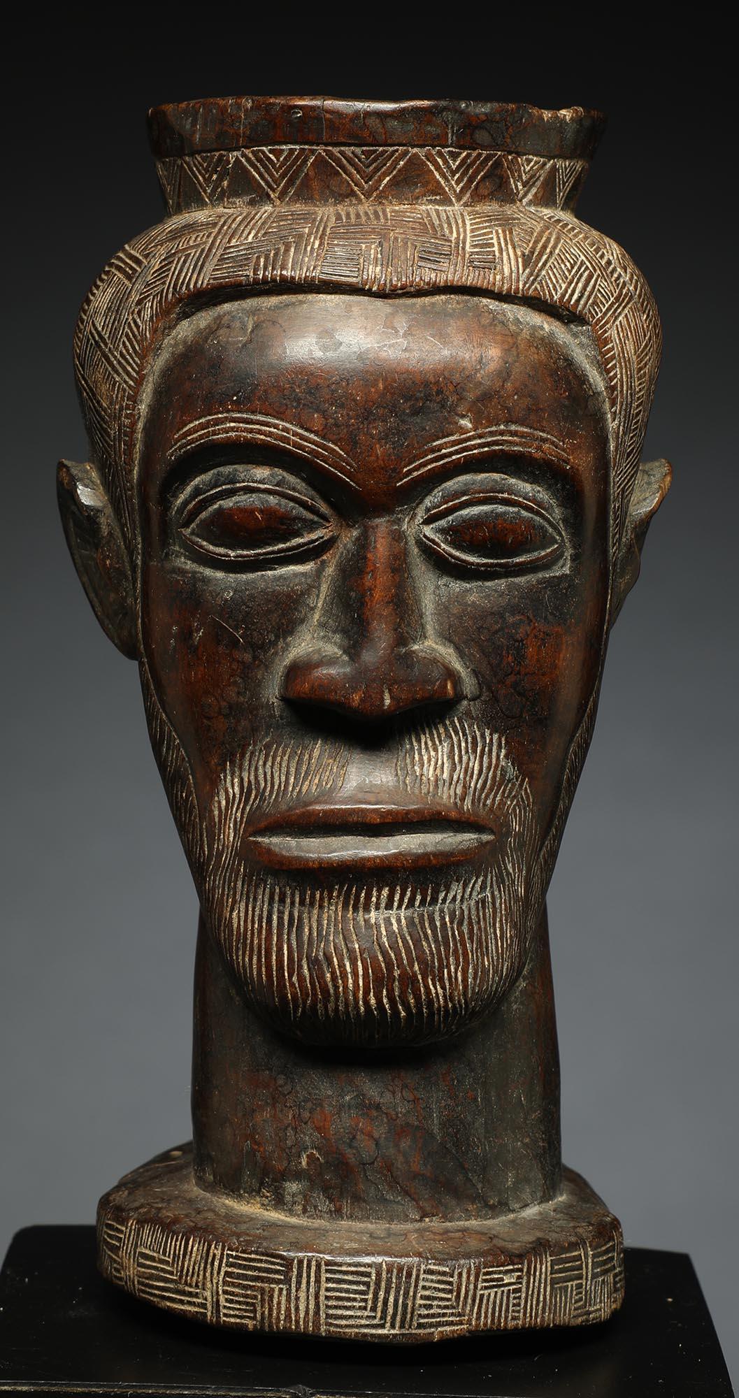 Early finely carved hard wood tribal Kuba figural cup, Congo with rich patina. In the form of a stylized male face with finely carved beard. Wonderful asymmetrical incised classic Kuba crisscross design for hair. Deep patina from extensive use,
