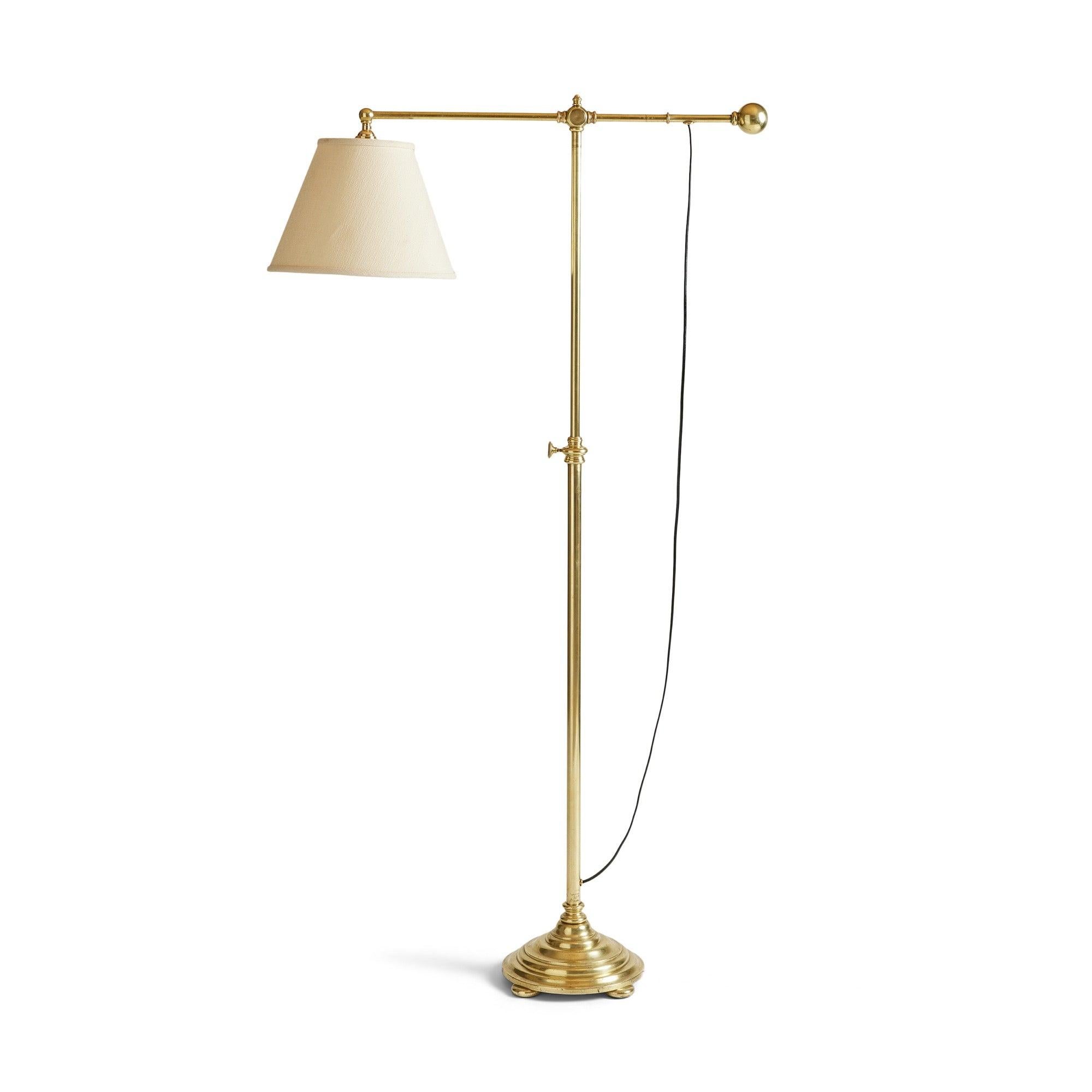 Lampada da terra in ottone dal design minimalista con asta regolabile in altezza, su una base a gradini.